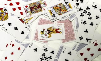 Playing cards scattered on a white surface.