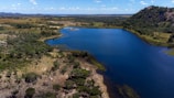 A serene lake surrounded by lush, green landscape.