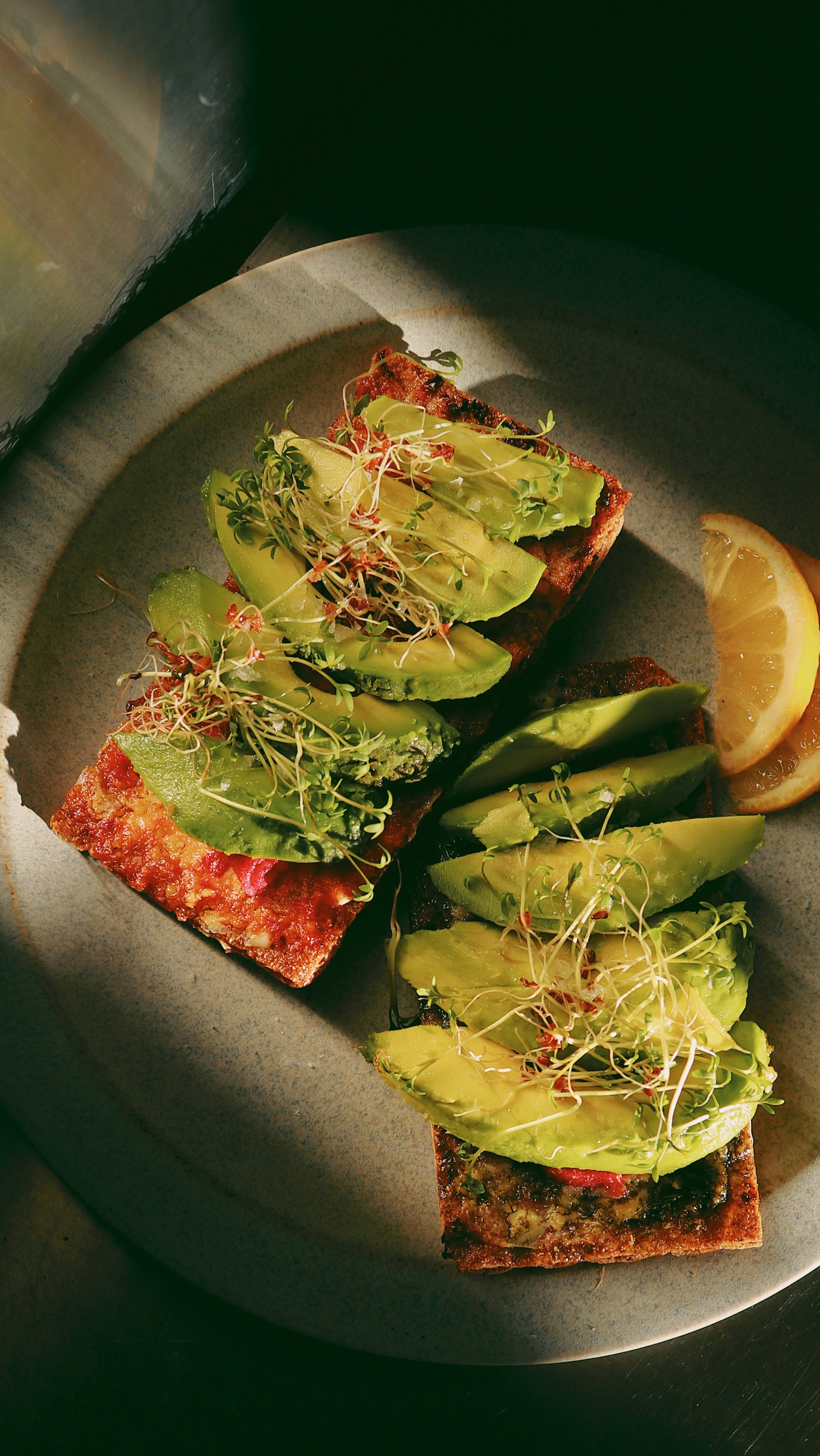 Avocado toast with sprouts and lemon.