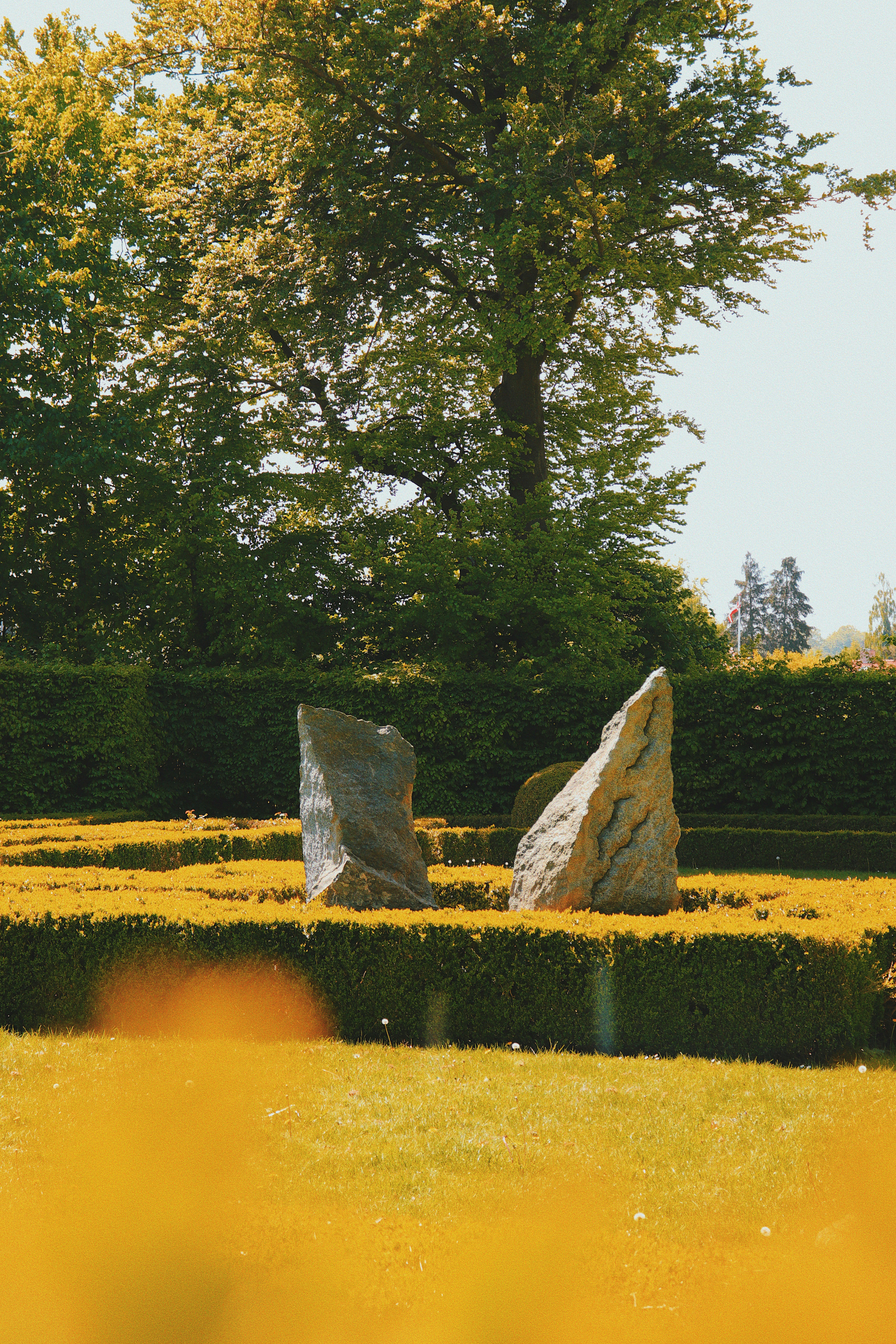 Two stone sculptures in a manicured garden.