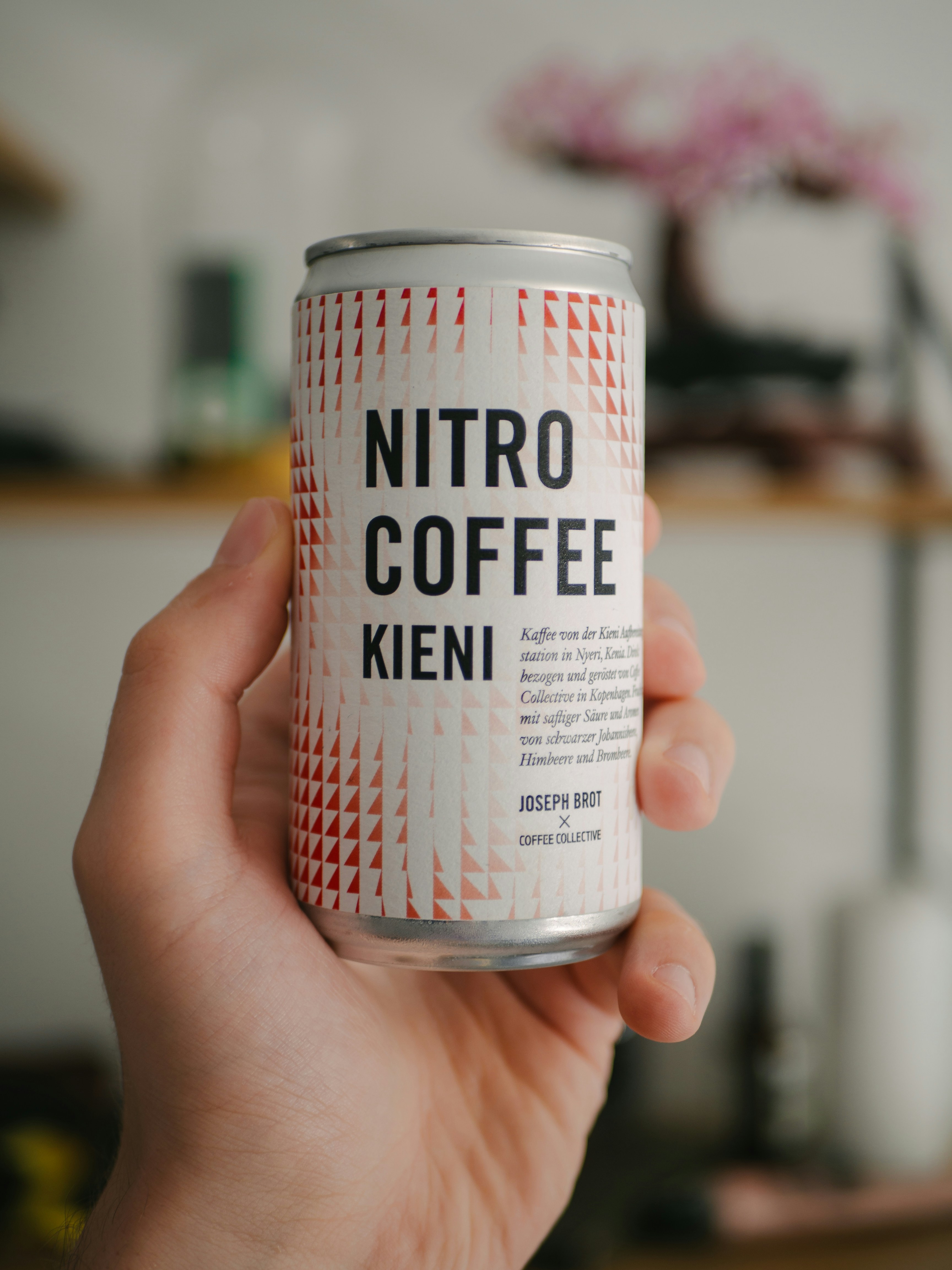 A hand holds a can of nitro coffee.