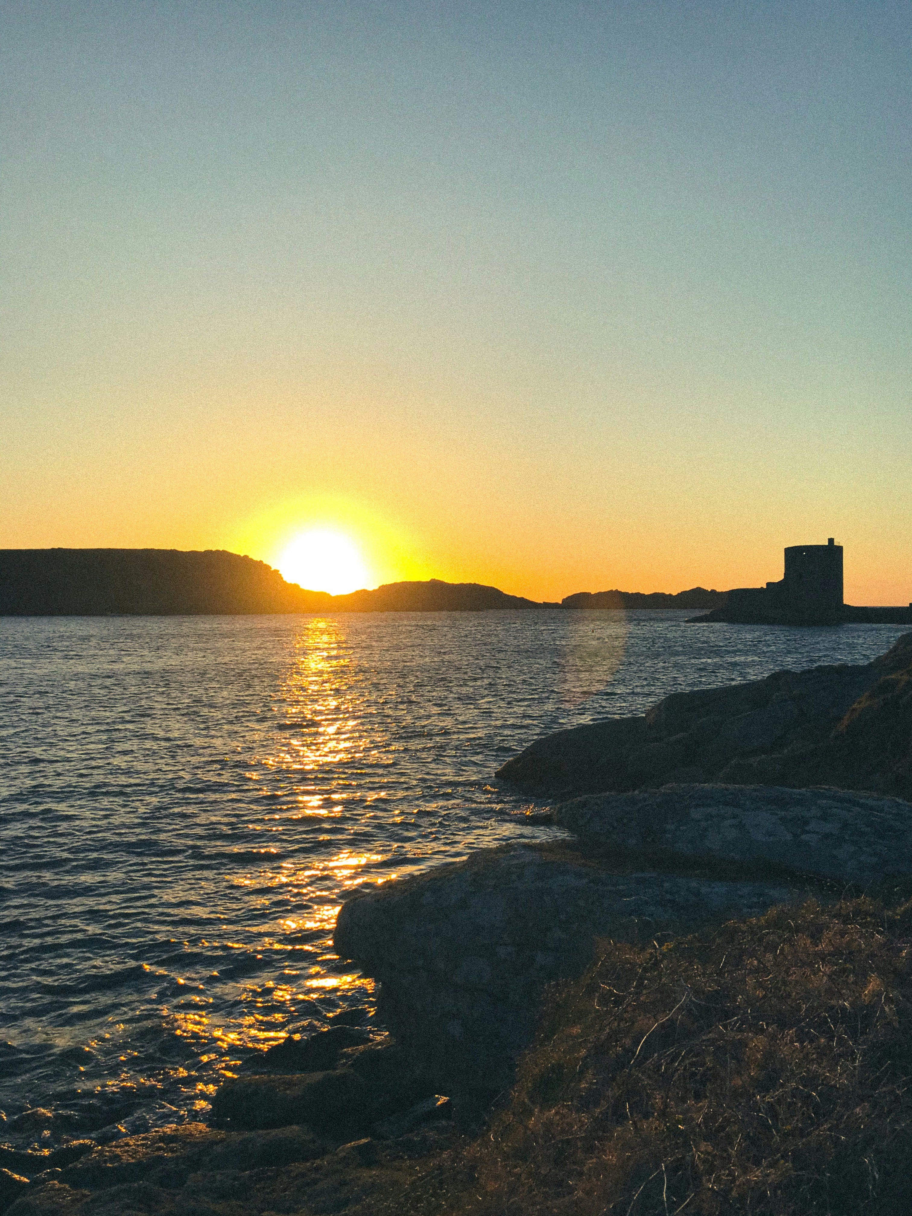 Sunset over the sea and a distant island.