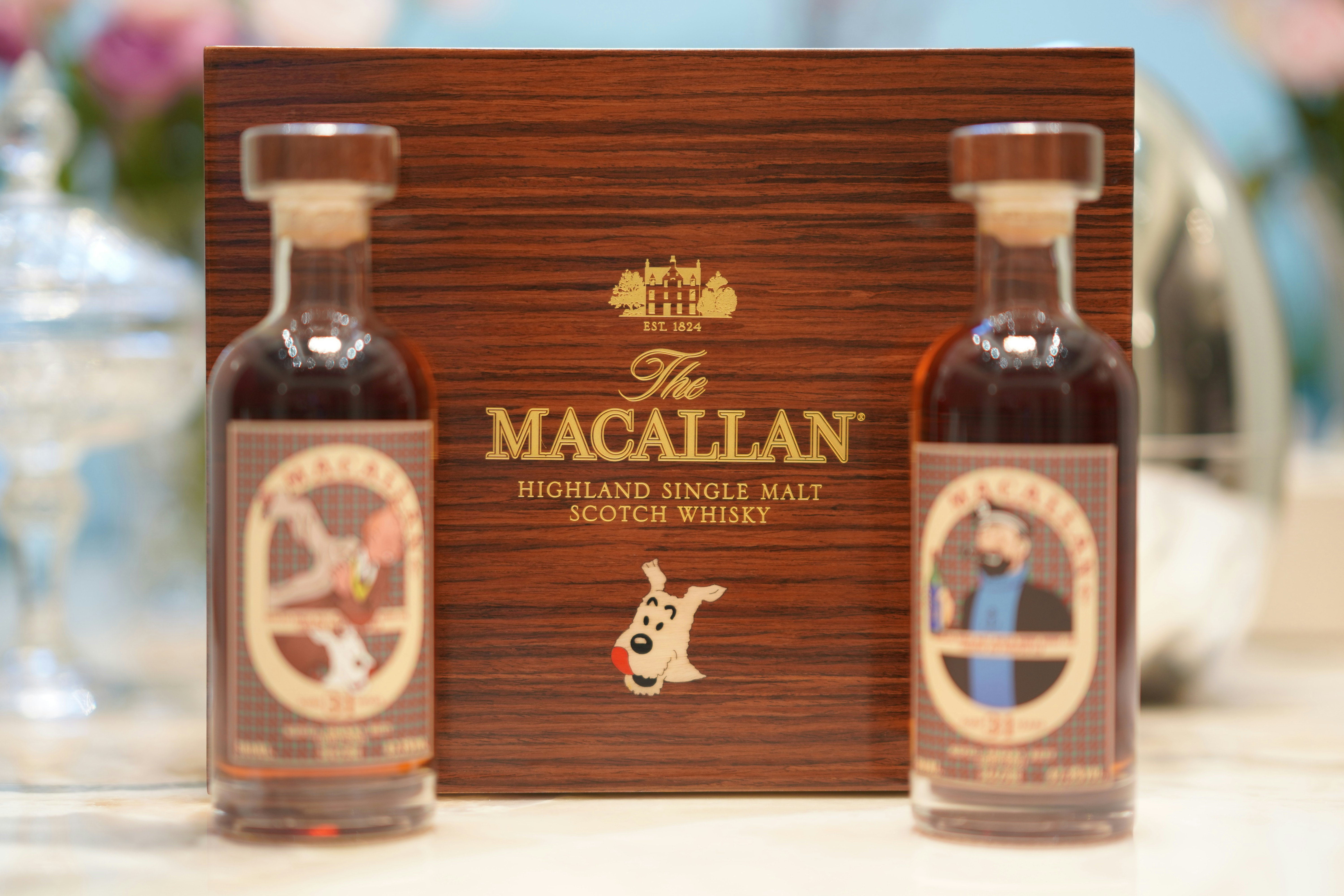 Miniature macallan bottles sit in a box.