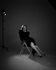 A woman poses in a dark dress in studio