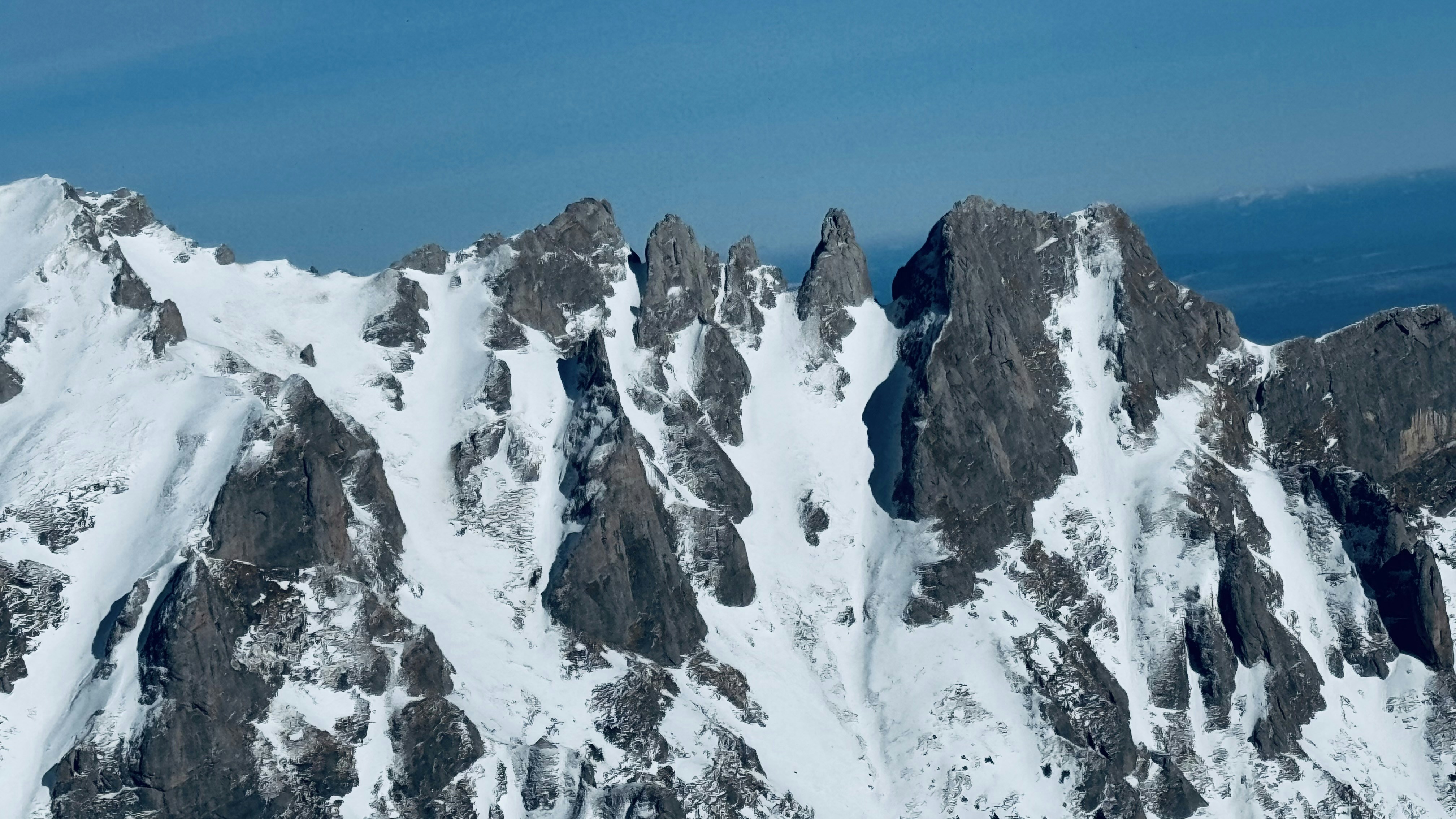 Snow-capped mountain peaks against a blue sky.