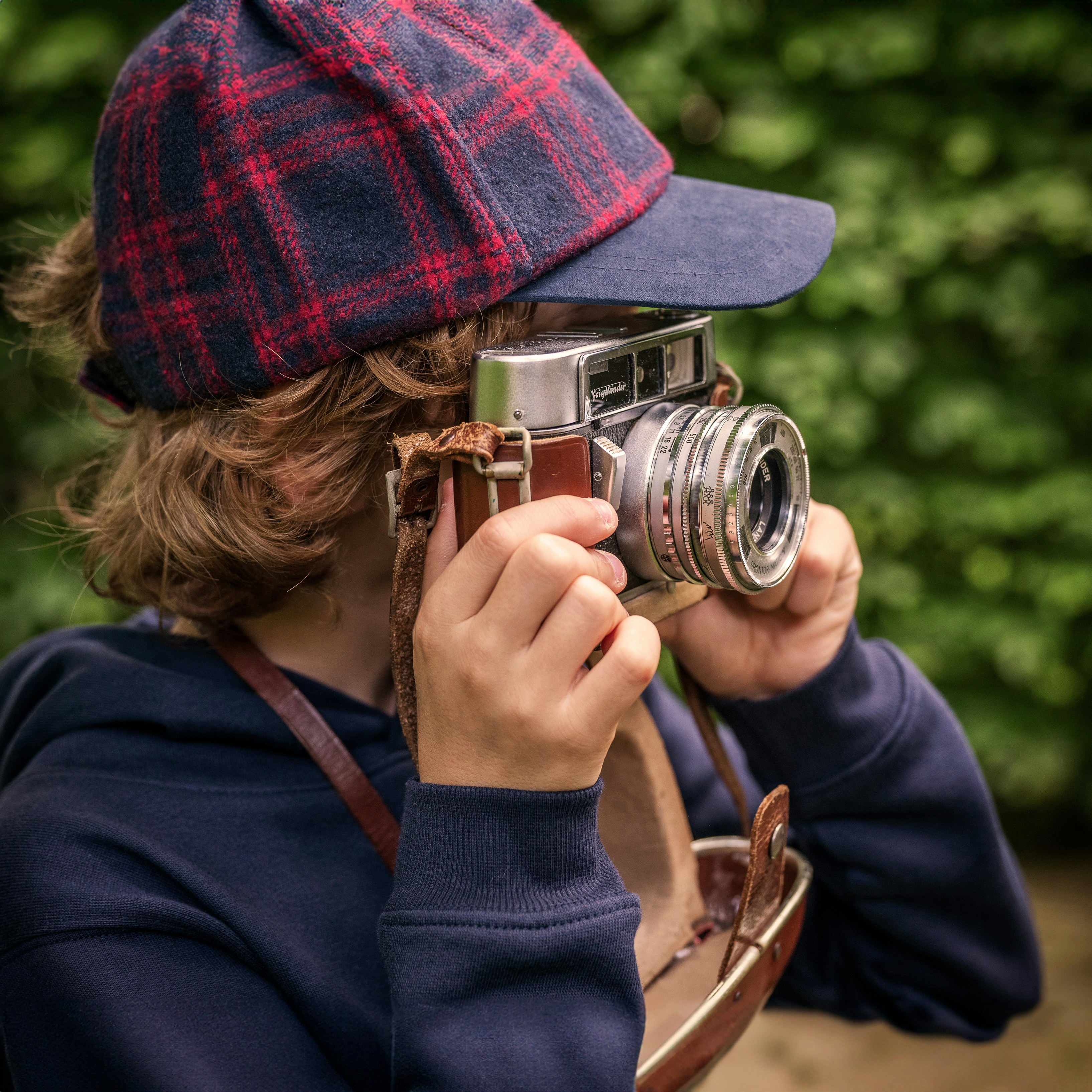 A young person takes a photo with a vintage camera