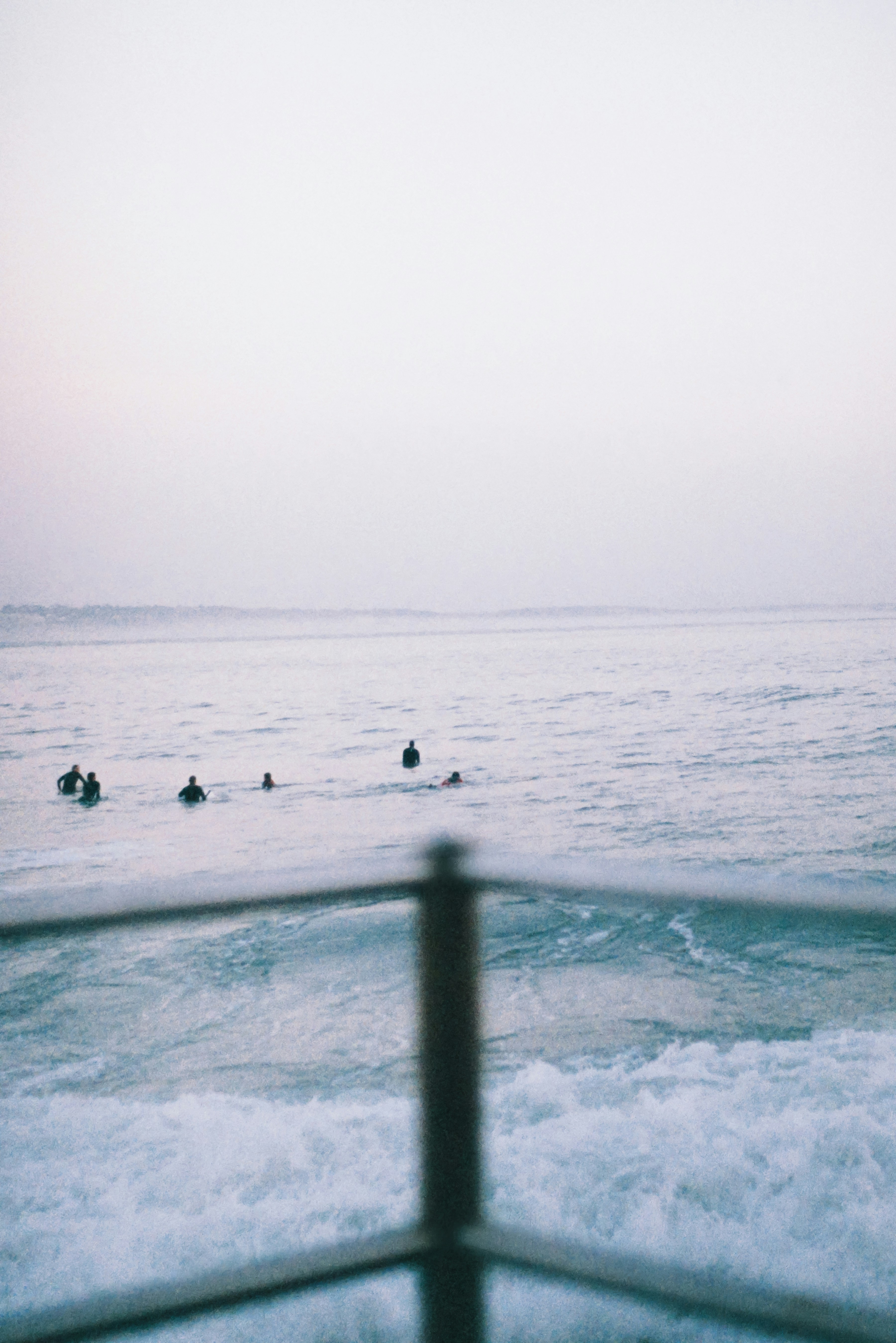 Surfers are enjoying the ocean waves at dawn.