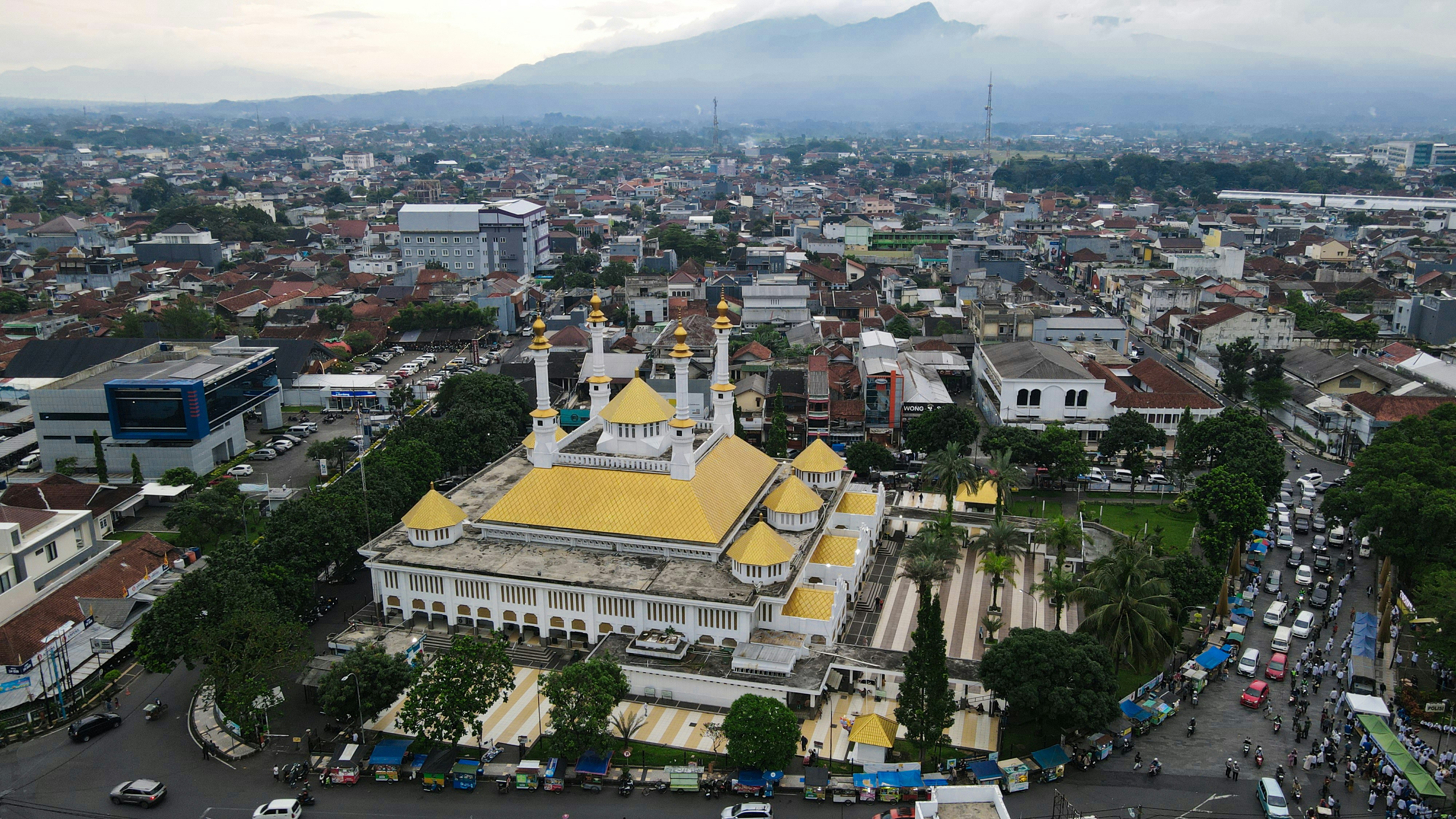 Aerial view of a mosque in a bustling city.
