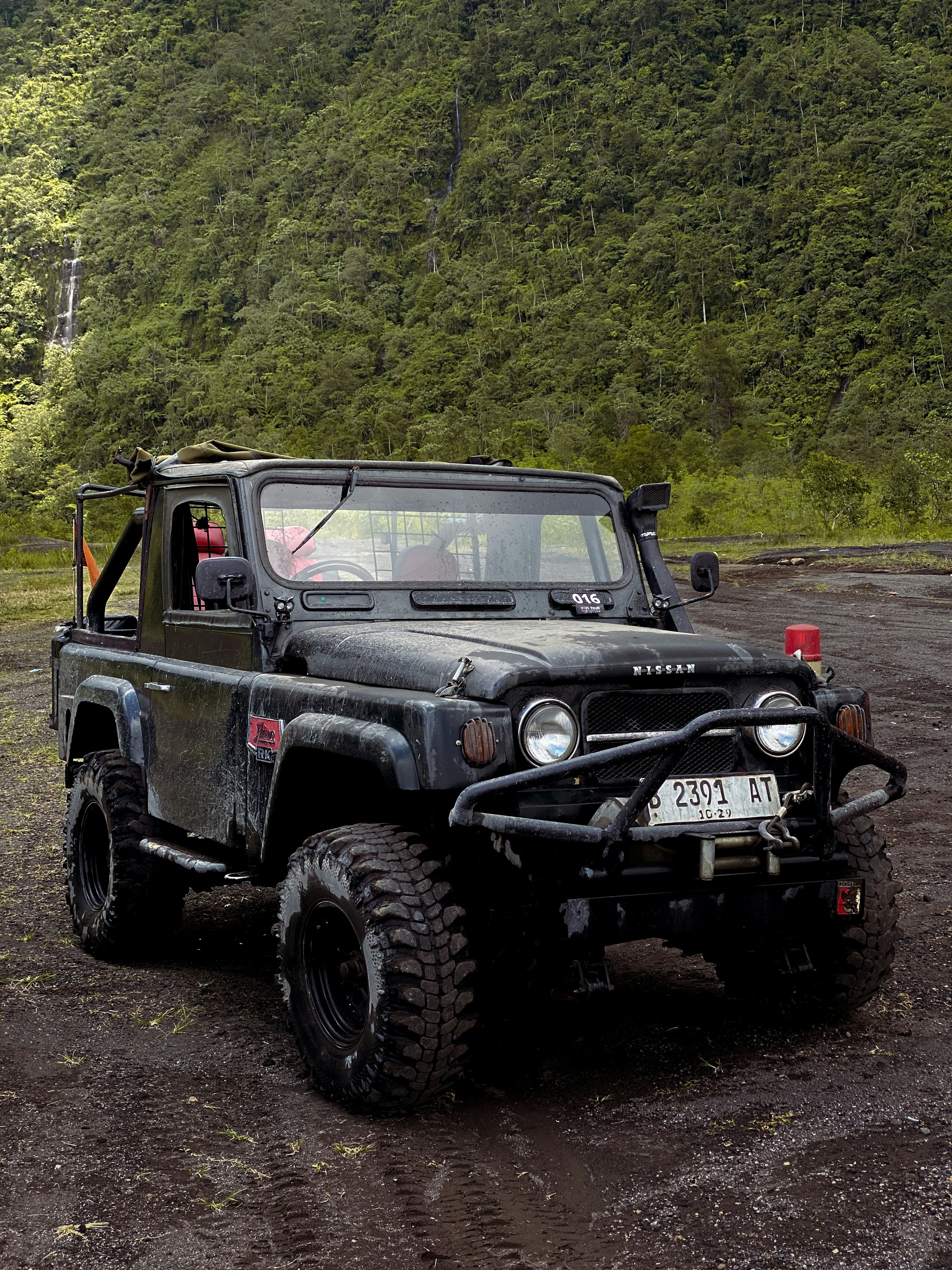 A rugged jeep stands on a dirt road.