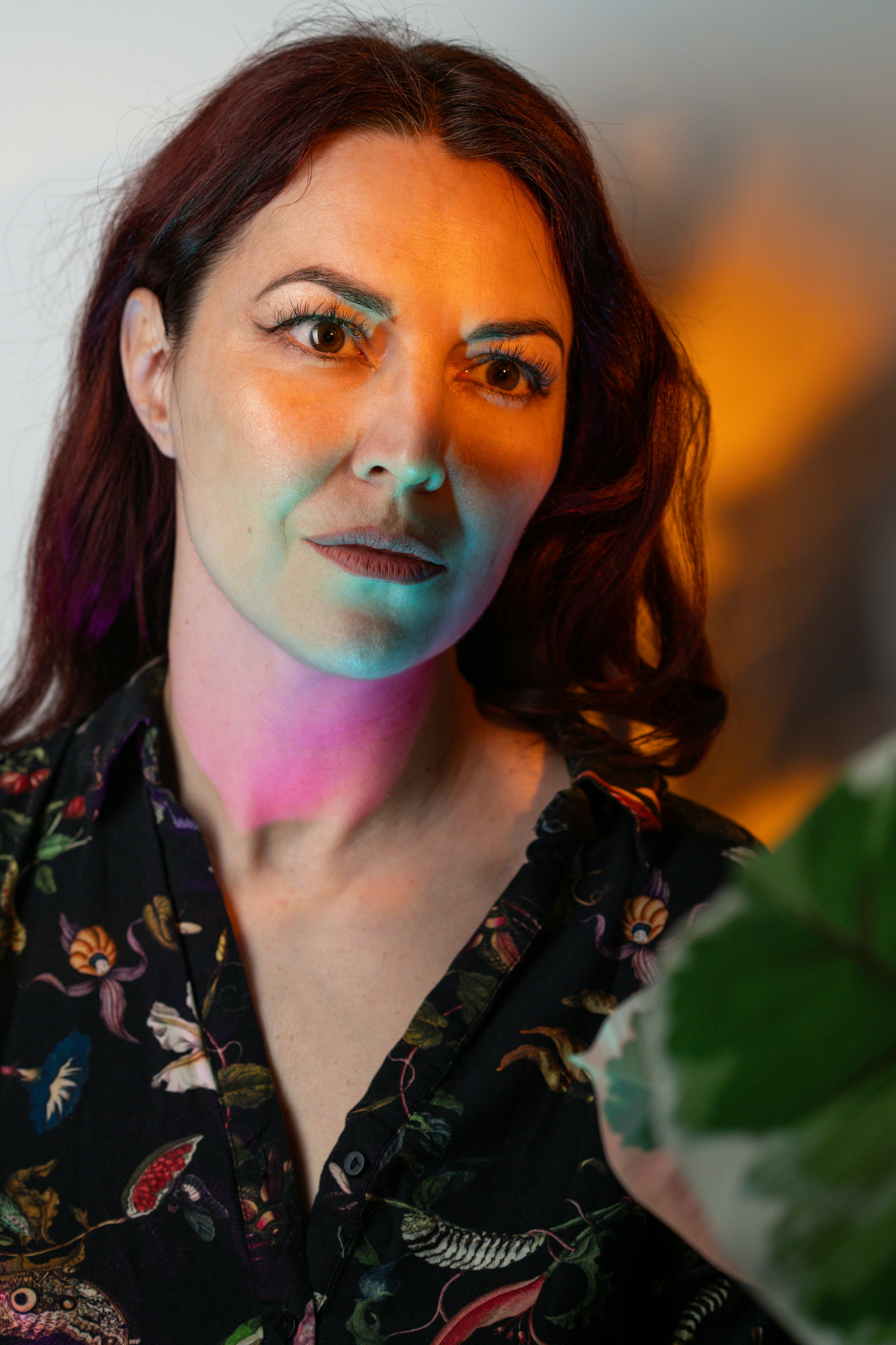 Frauenporträt mit farbenfroher, dramatischer Beleuchtung.