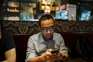 Man is looking at his phone in a restaurant