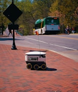 A delivery robot rolls on a sidewalk.