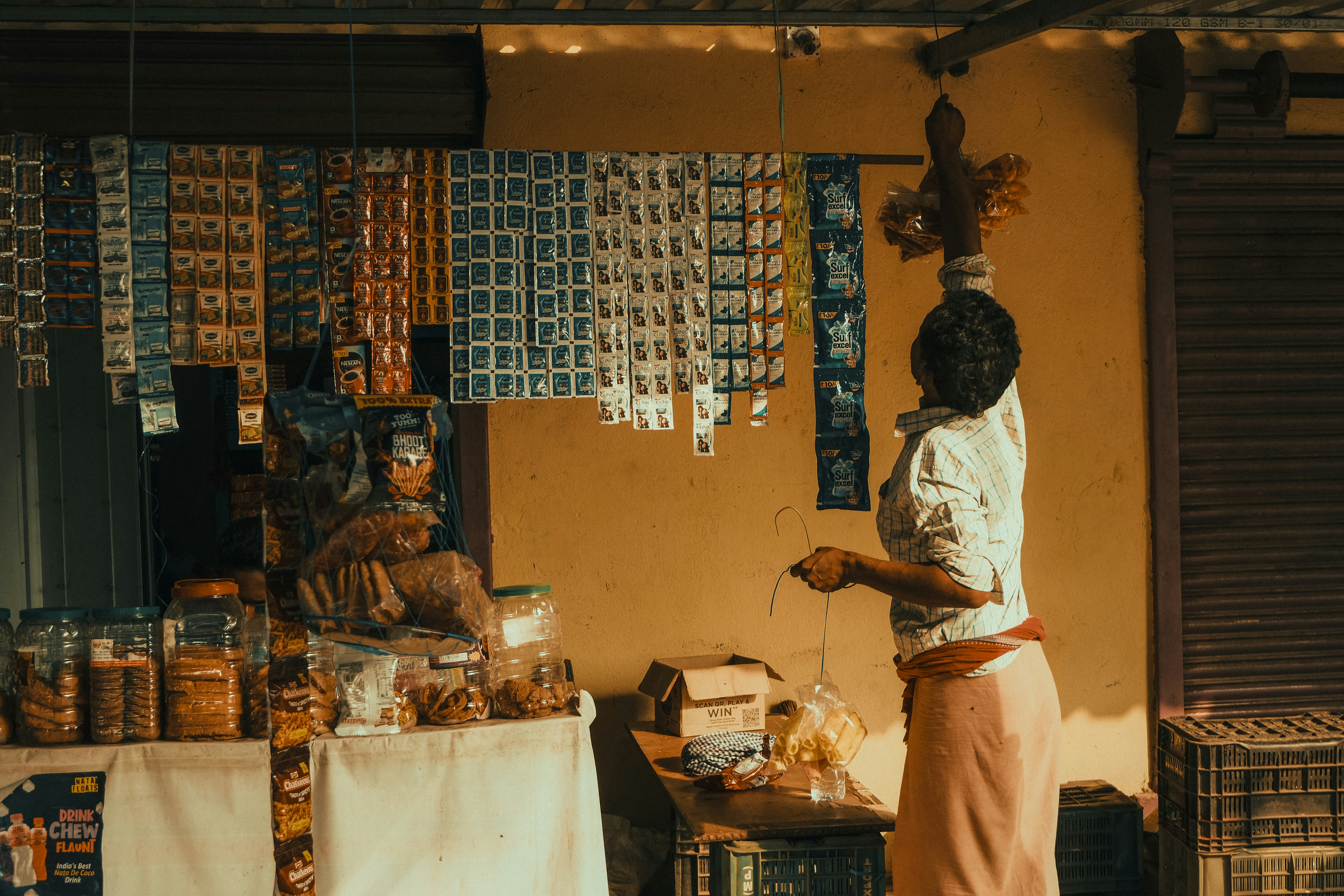 A person reaches up near a shop display.
