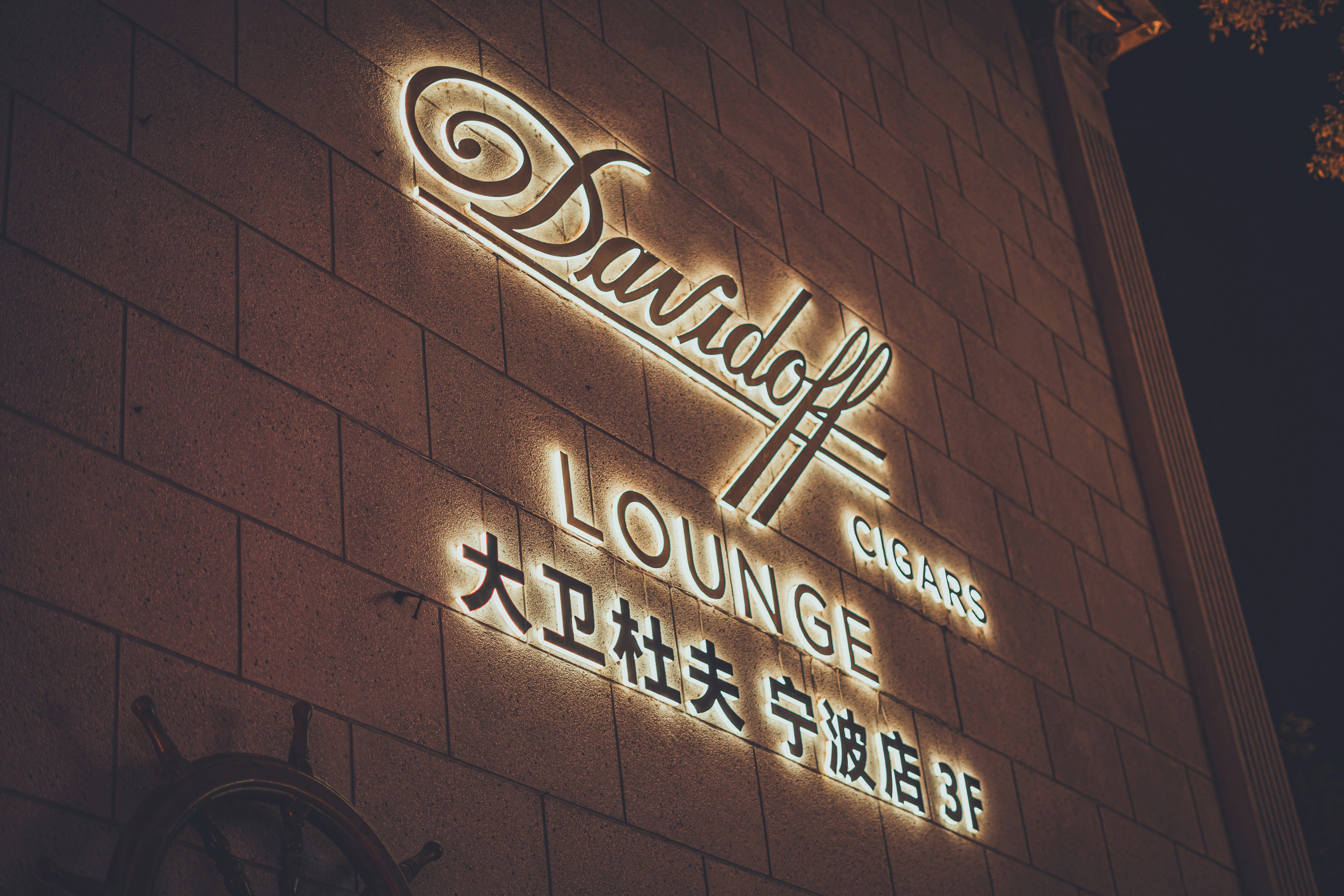 A lit-up davidoff lounge sign on a building.