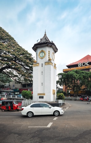 The clock tower stands tall amidst the city traffic.