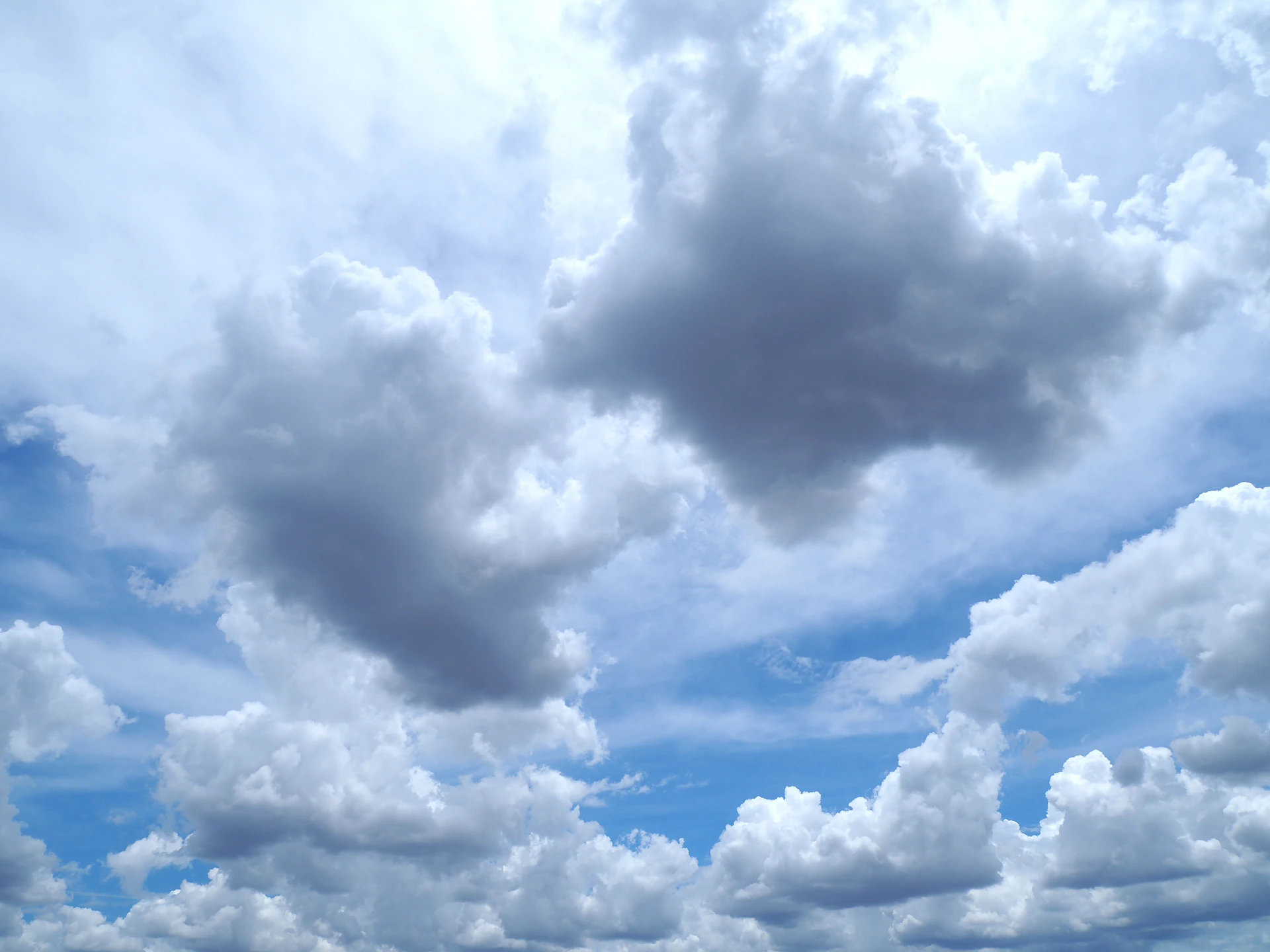 Fluffy clouds against a brilliant blue sky.