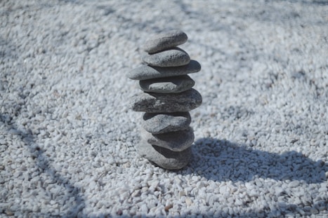 A stacked stone tower rests on white gravel.