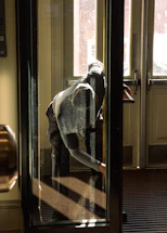 A person looks out a glass door.