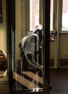 A person looks out a glass door.
