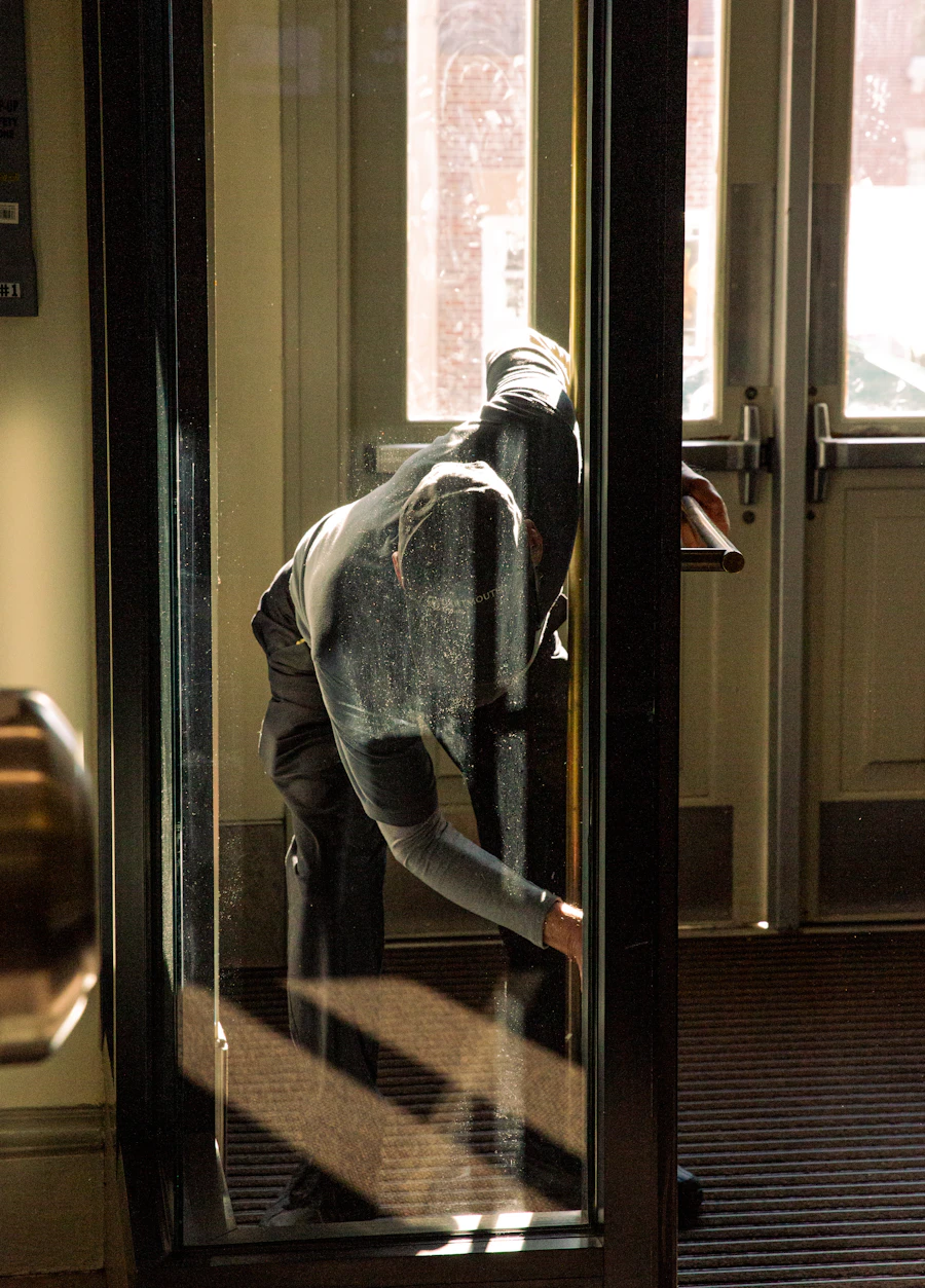 Person bei der Fensterreinigung an einer Glastür