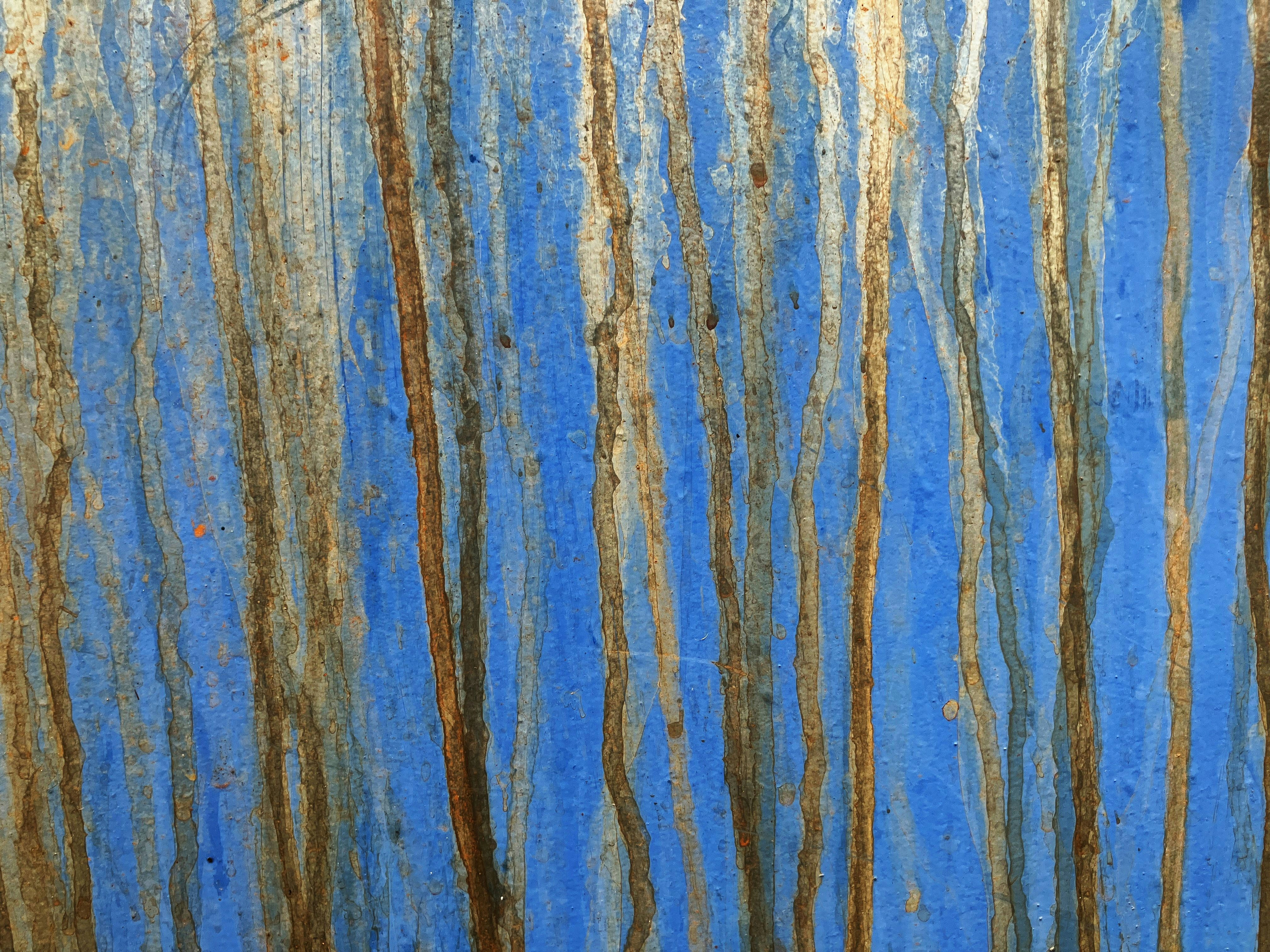 Blue wall with paint drips.