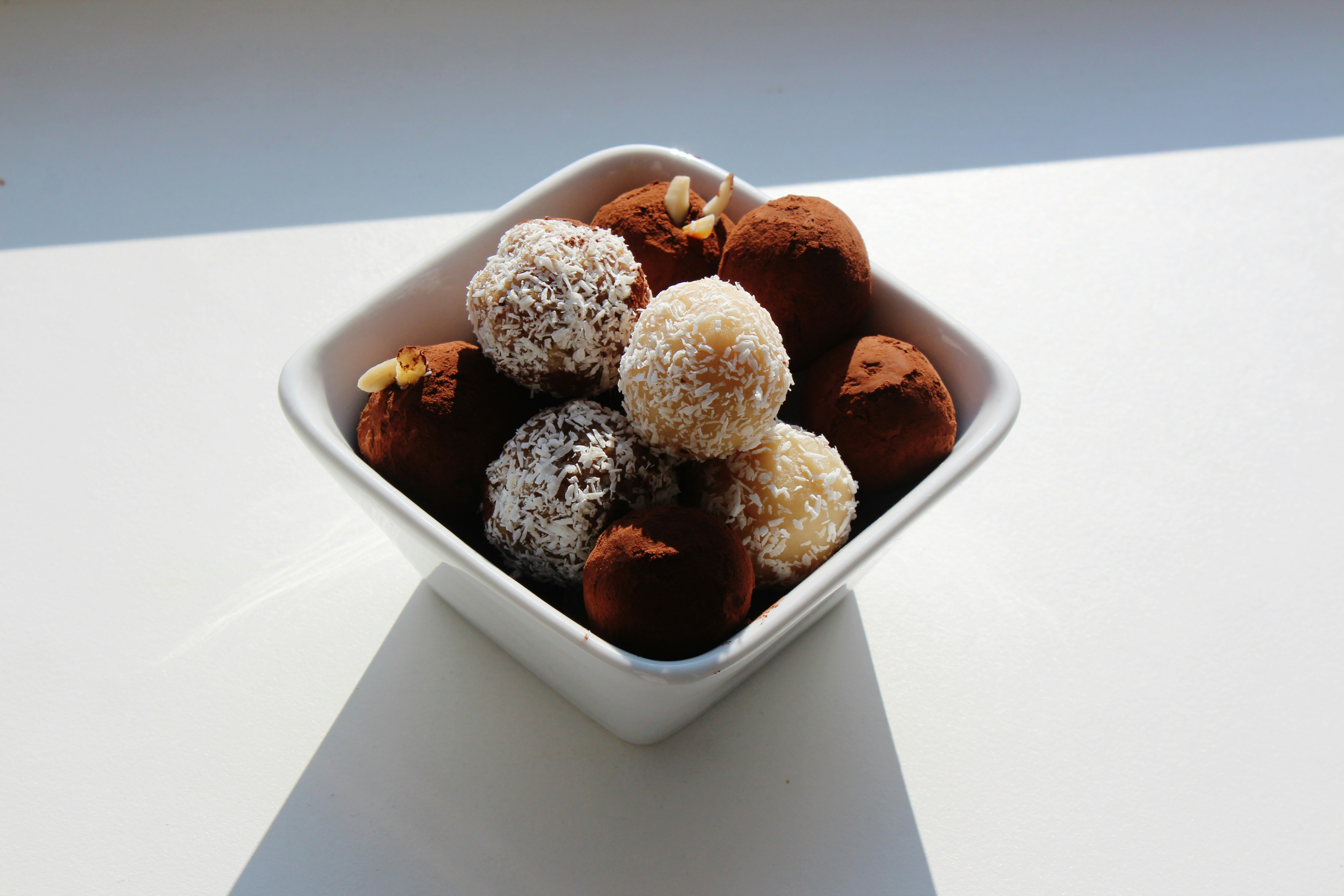 Delicious truffles are presented in a white bowl.