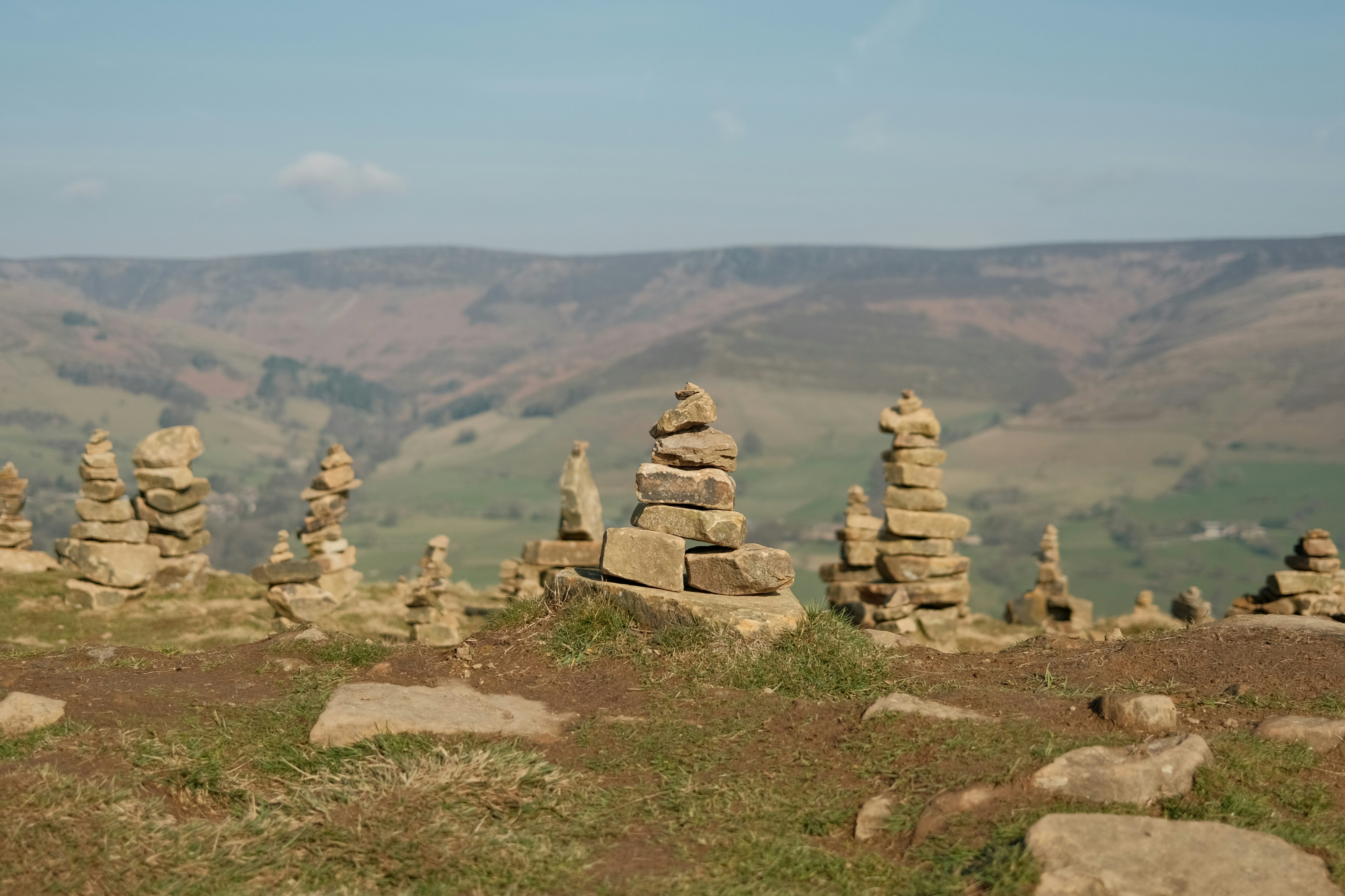 Stone cairns stand atop a grassy hill.
