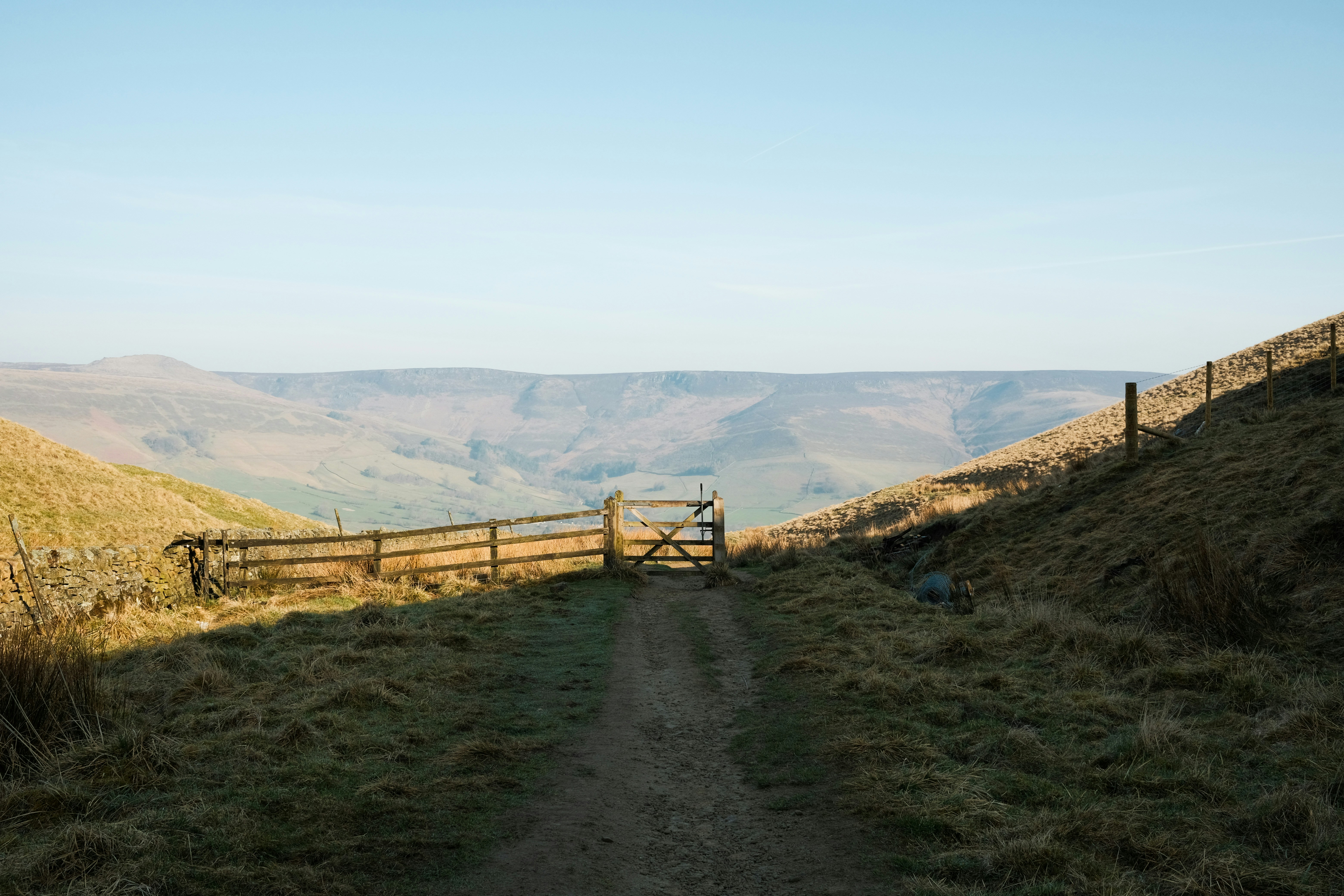 A gate opens onto a grassy, scenic landscape.