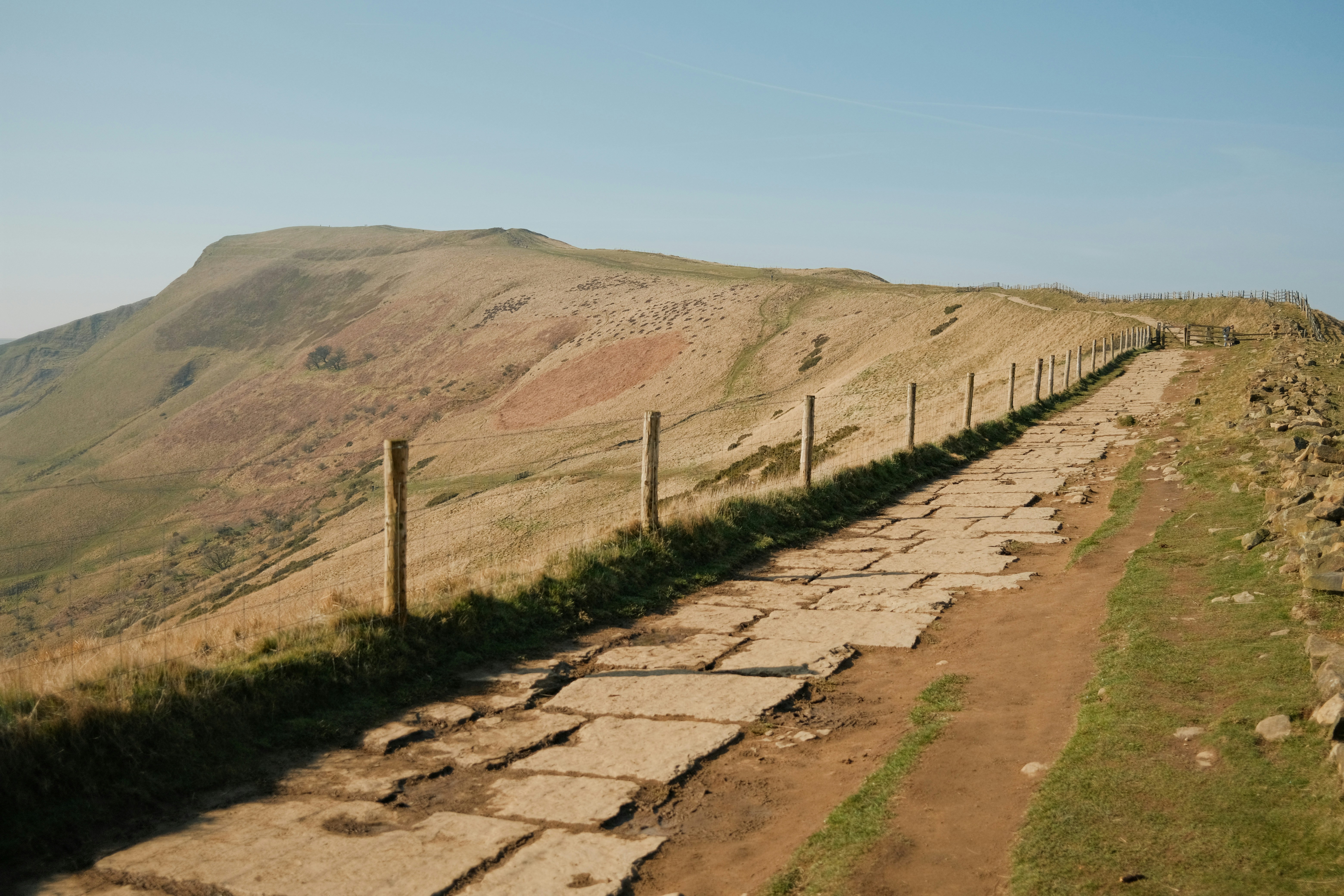 A stone path leads up a grassy hill.
