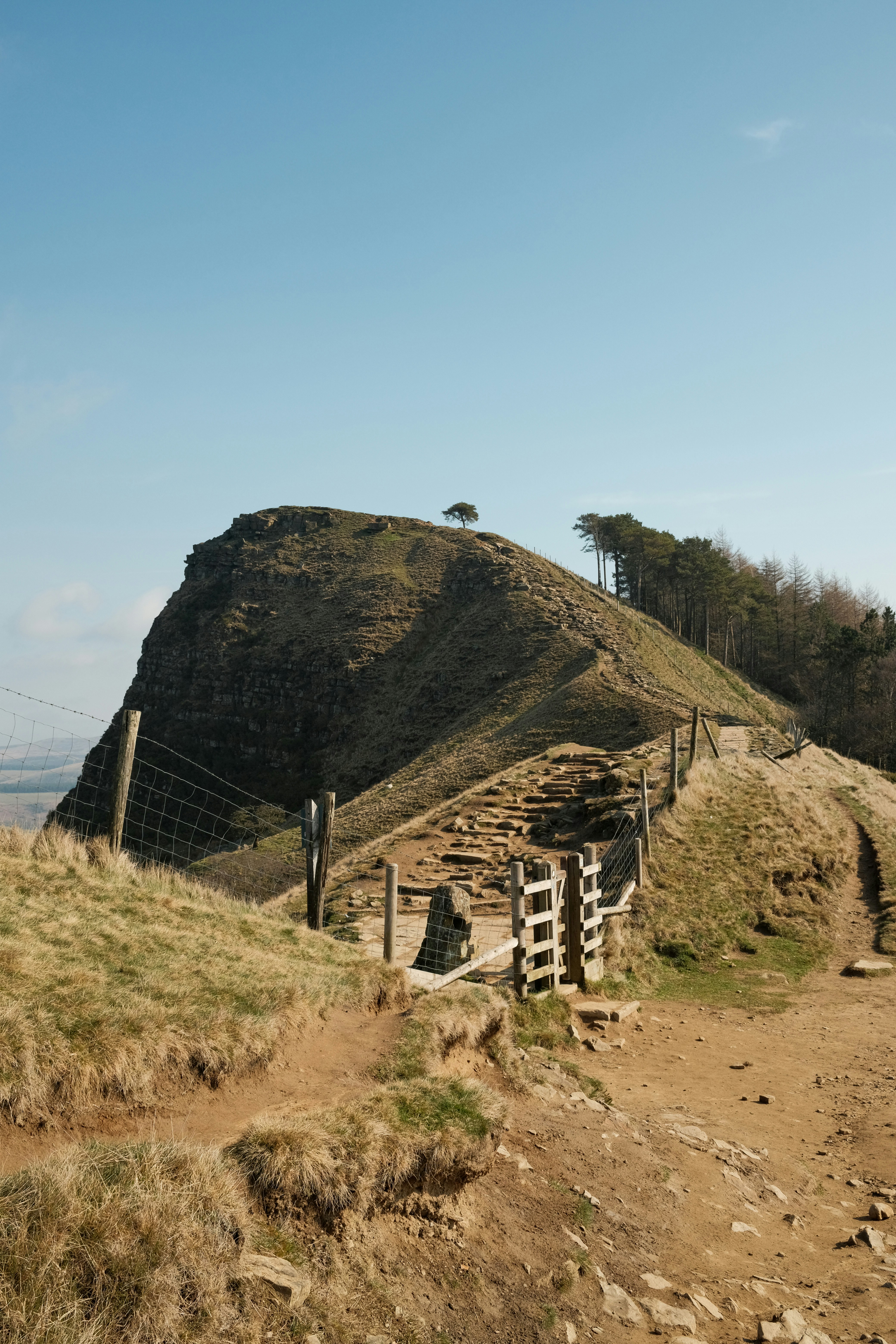 A scenic hilltop with a wooden fence and gate.