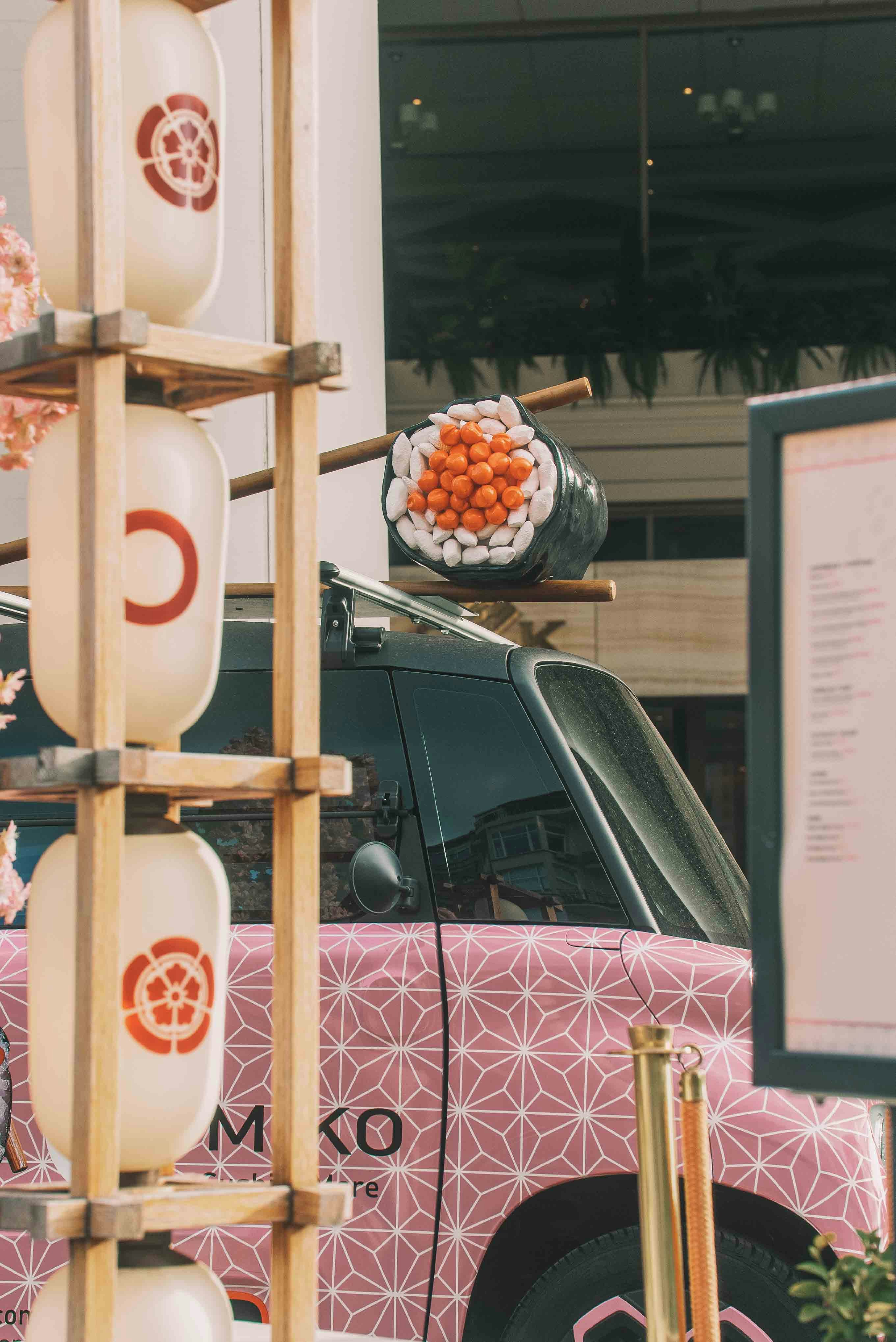 Sushi is on a car decorated for a festival.