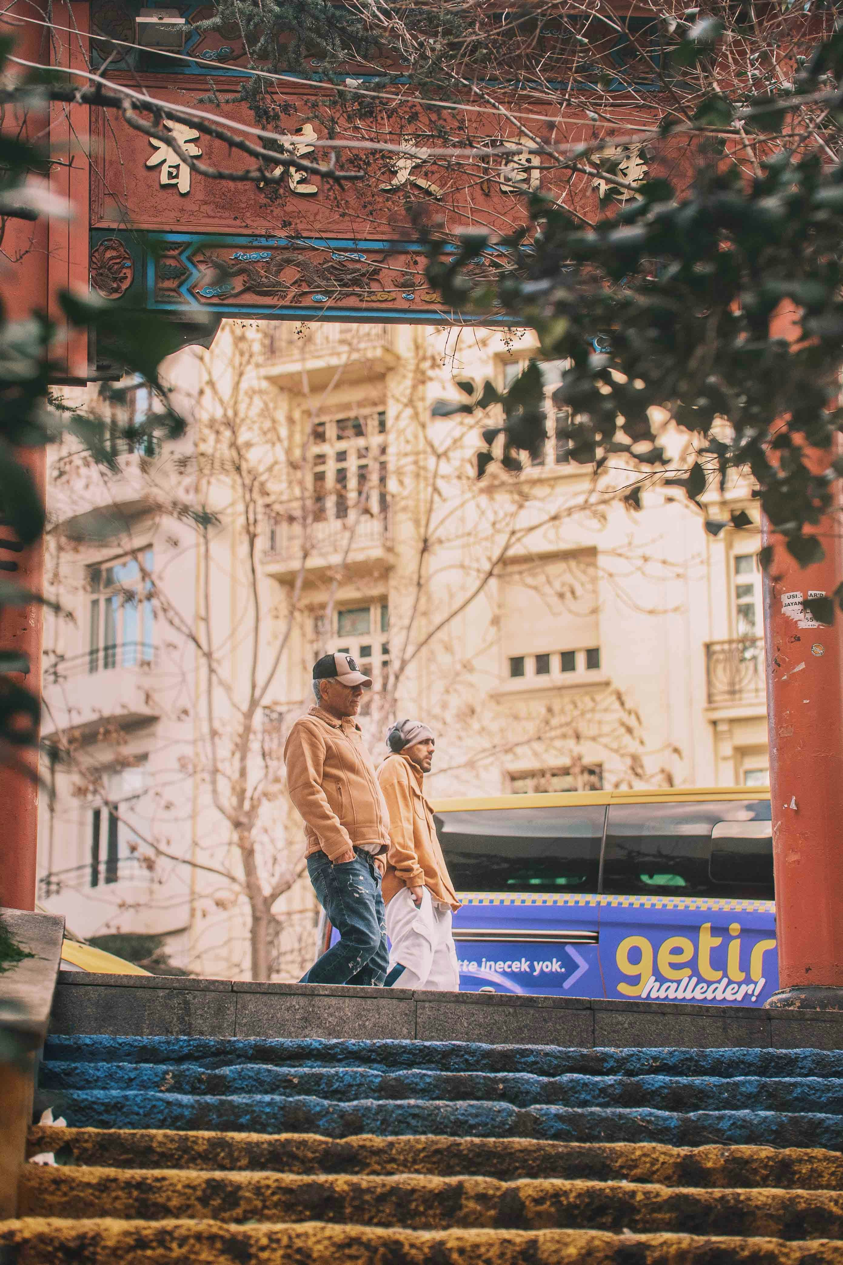 People walk through a chinese archway.