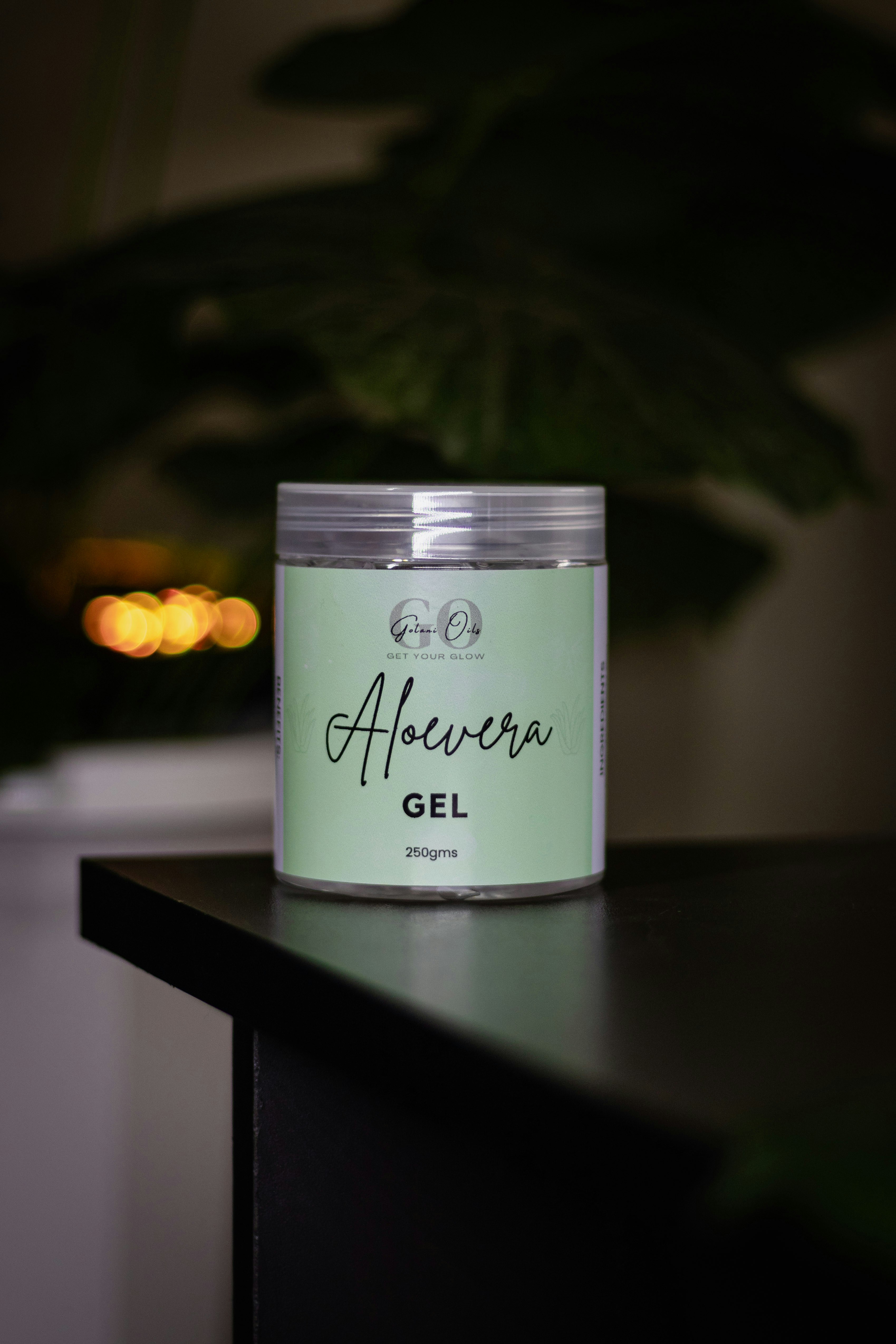 Aloe vera gel jar sits on a black table.