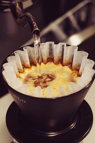 Pouring hot water over coffee grounds.