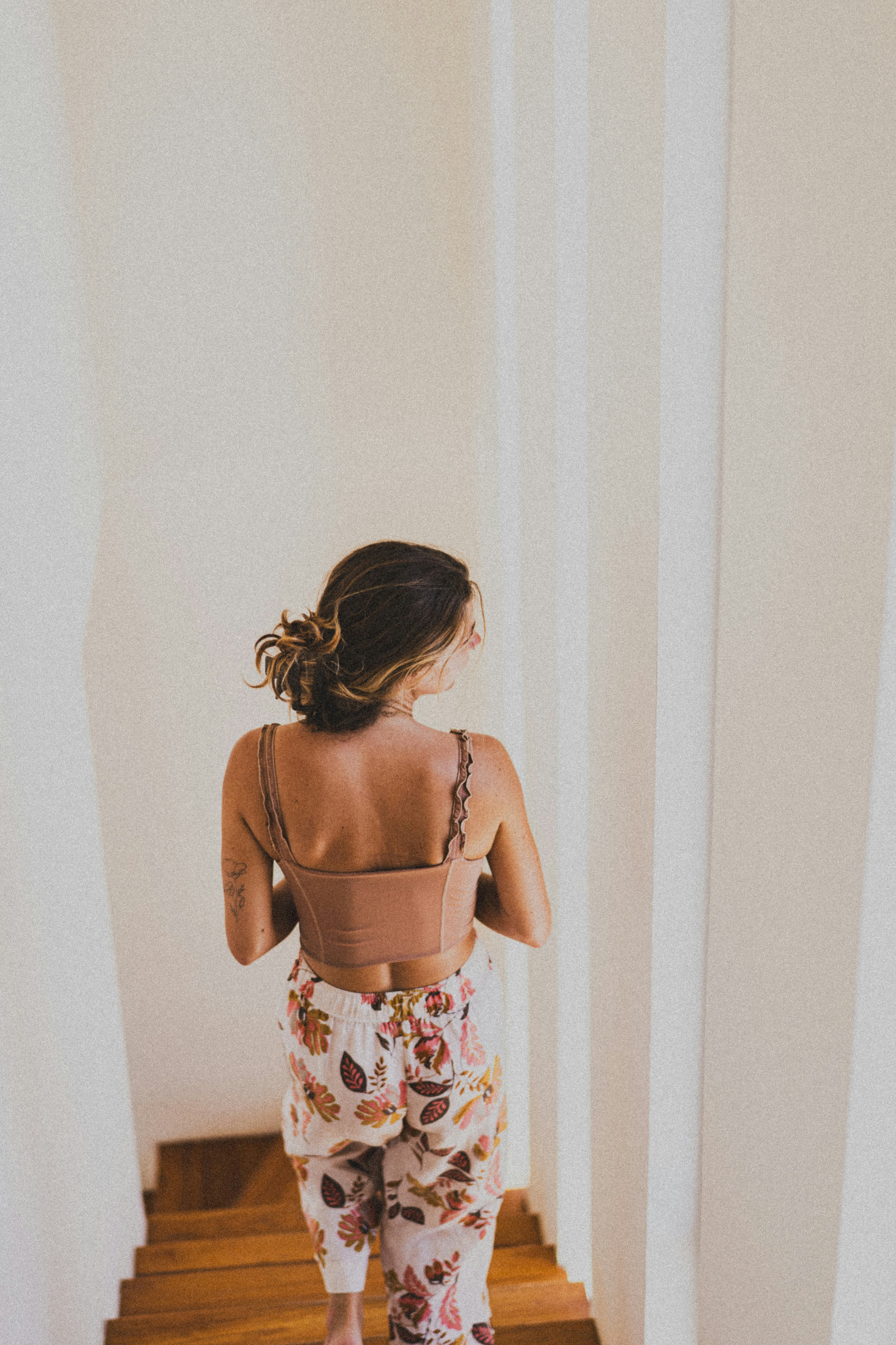 Woman descends the stairs in stylish clothing.