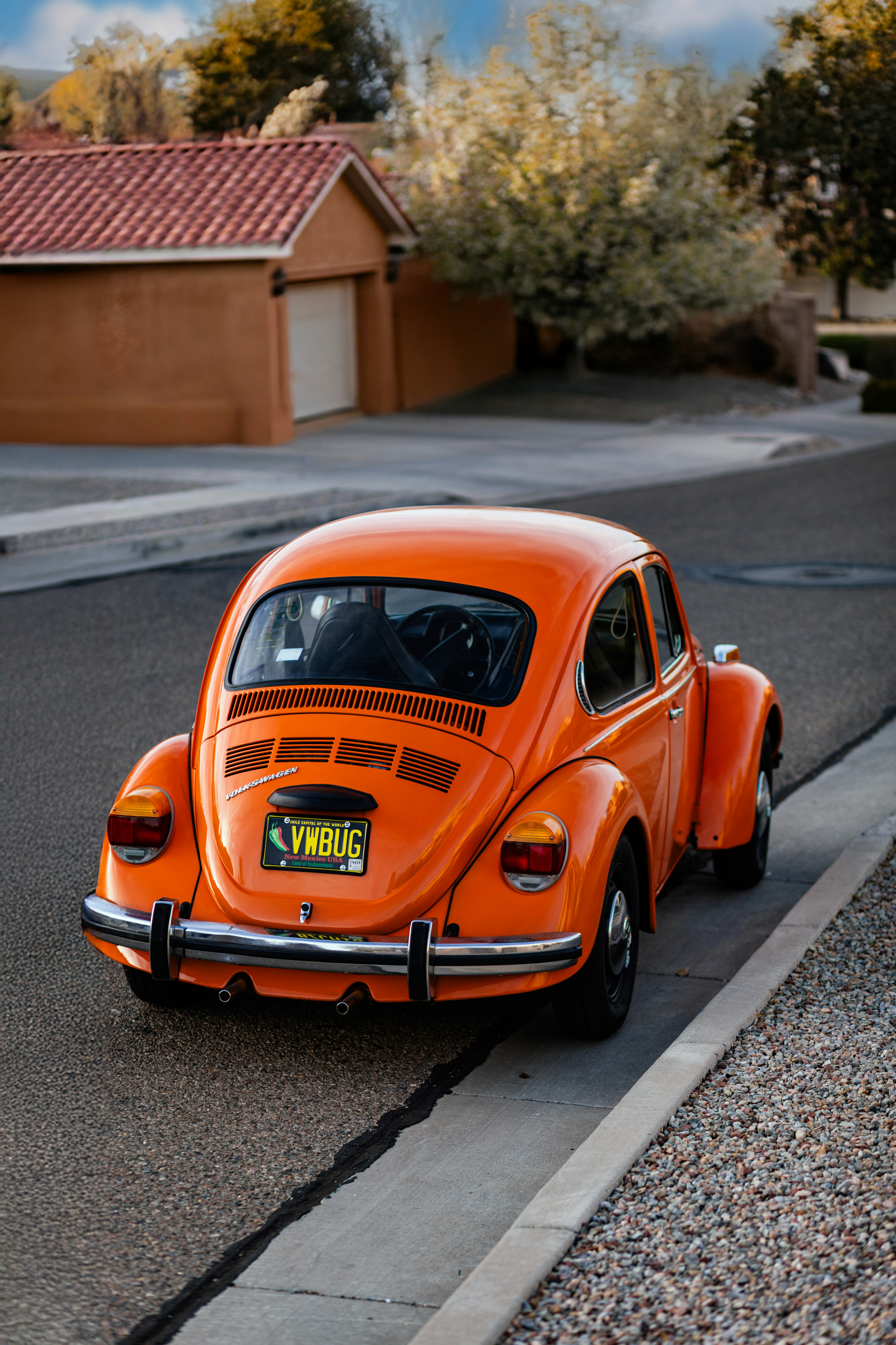 Orange volkswagen beetle parked on the street.