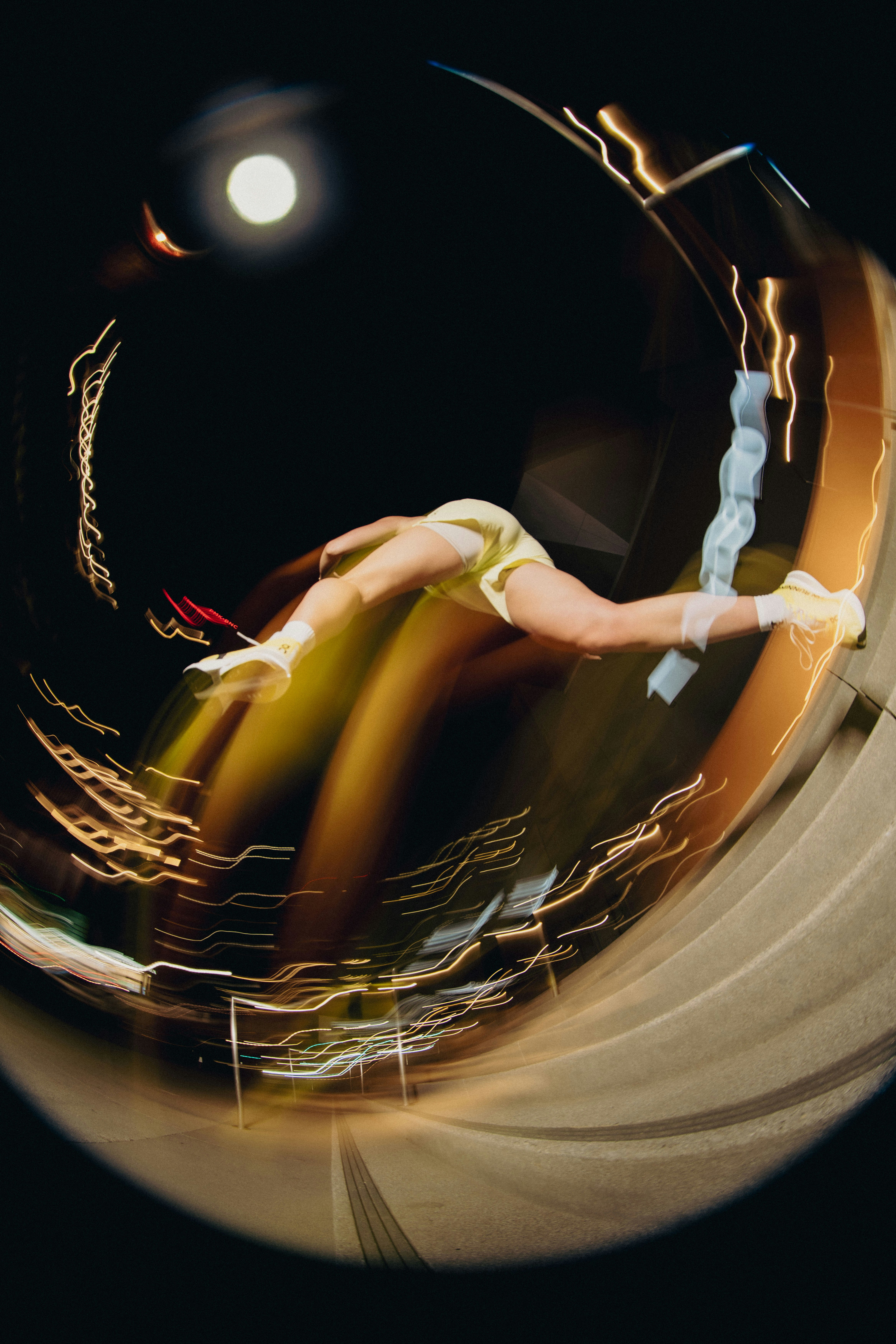 A person performs a gymnastic stunt at night.