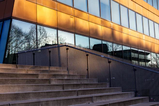 A modern building with steps and reflective windows.