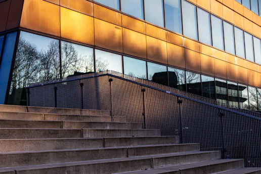 A modern building with steps and reflective windows.