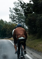 Two cyclists ride along a road.