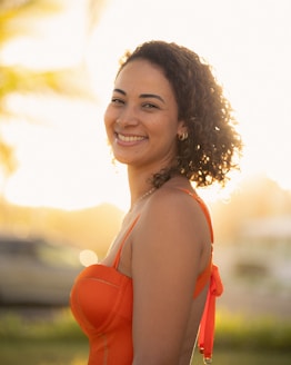 A woman smiles at the camera in bright sunlight.