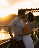 A couple shares a kiss during a sunset