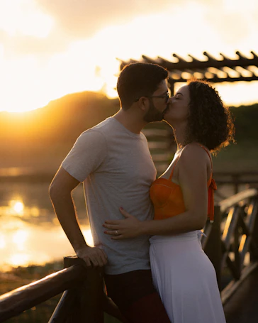 A couple shares a kiss during a sunset