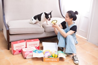 Woman and dog with treats and pawbox products.