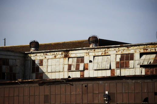 The image depicts a weathered industrial building.