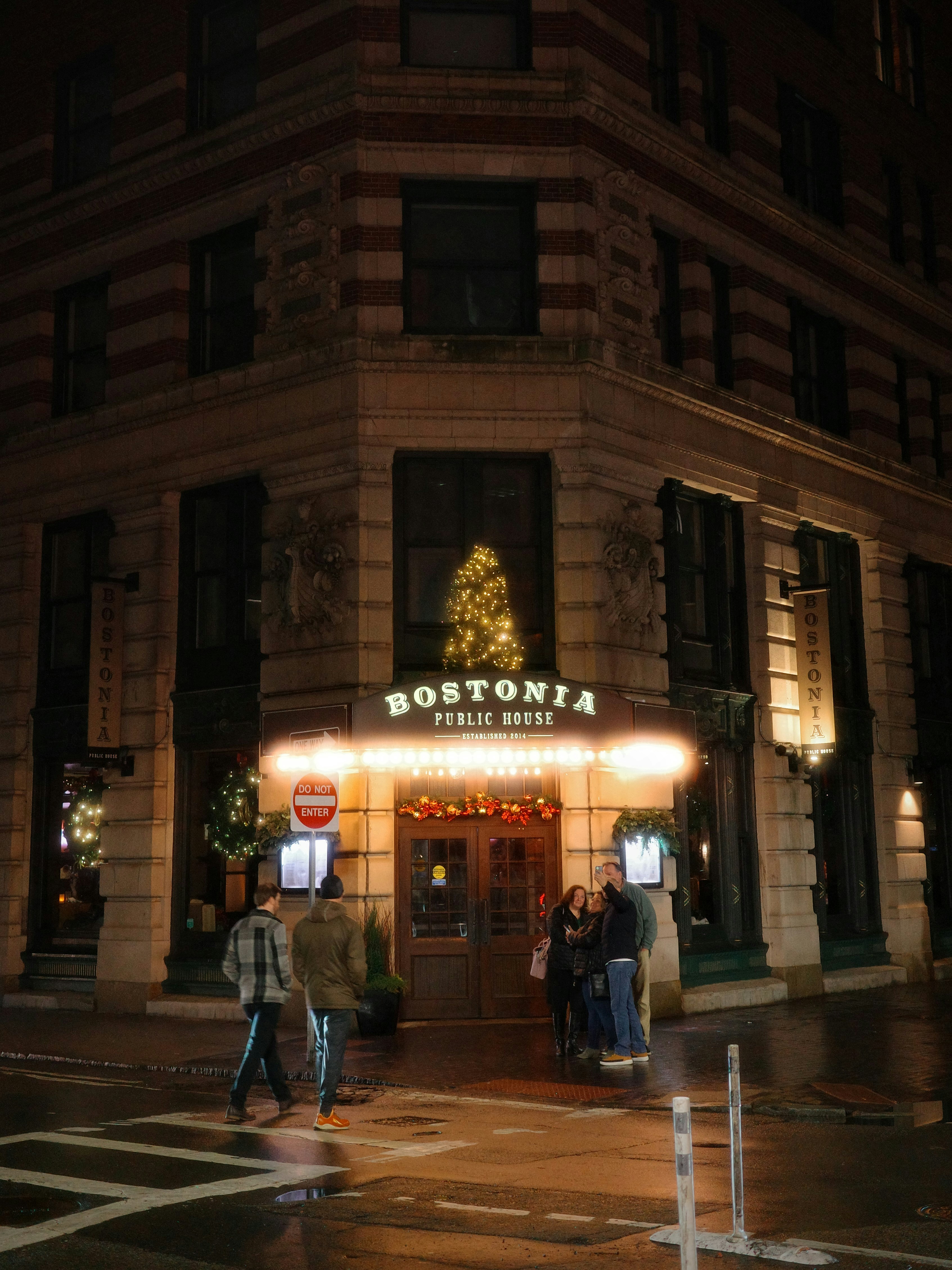 A public house entrance is illuminated at night.