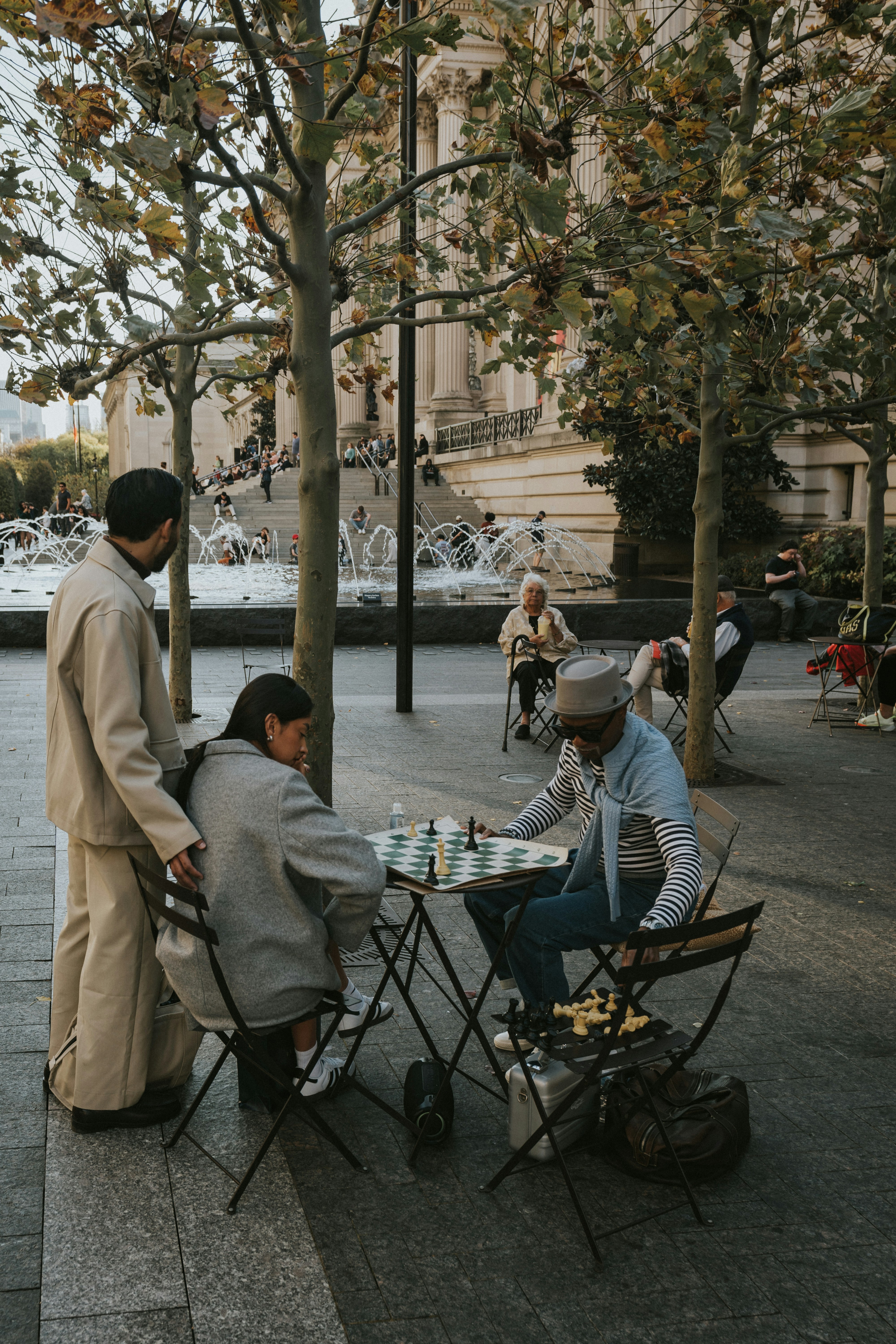 People are playing chess in a park setting.