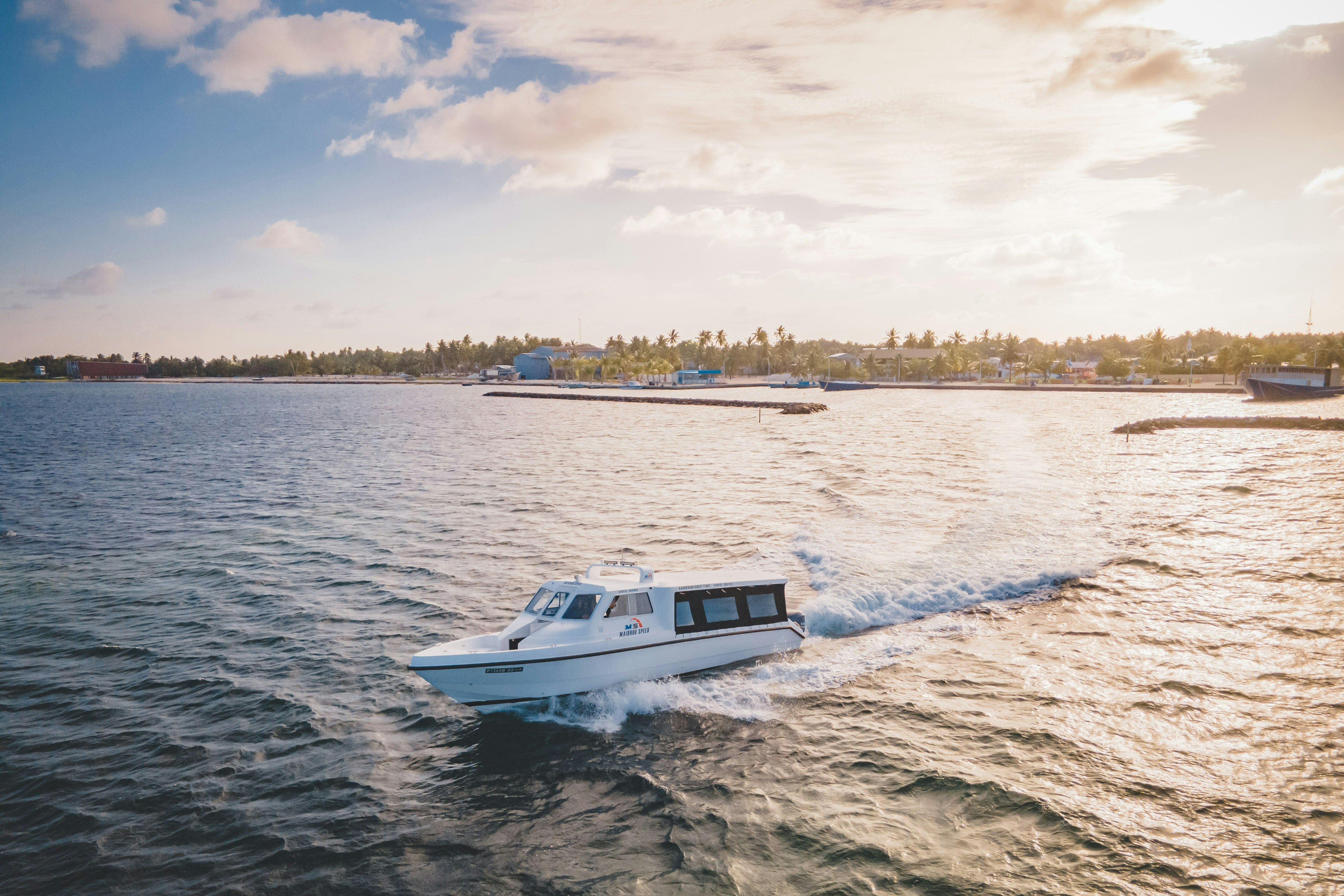 Boat cruises across the water on a beautiful day.
