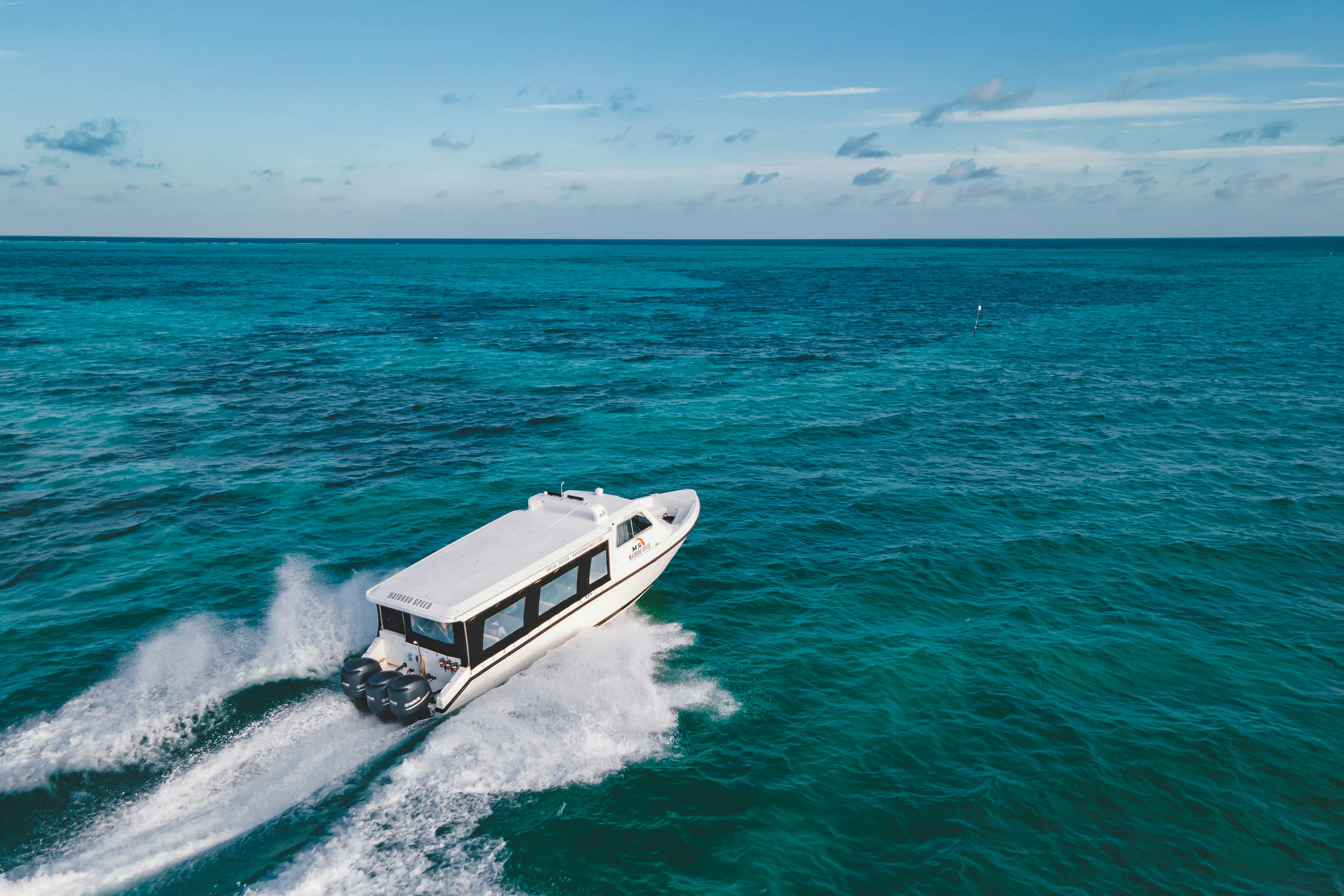 Boat speeding across bright turquoise water.