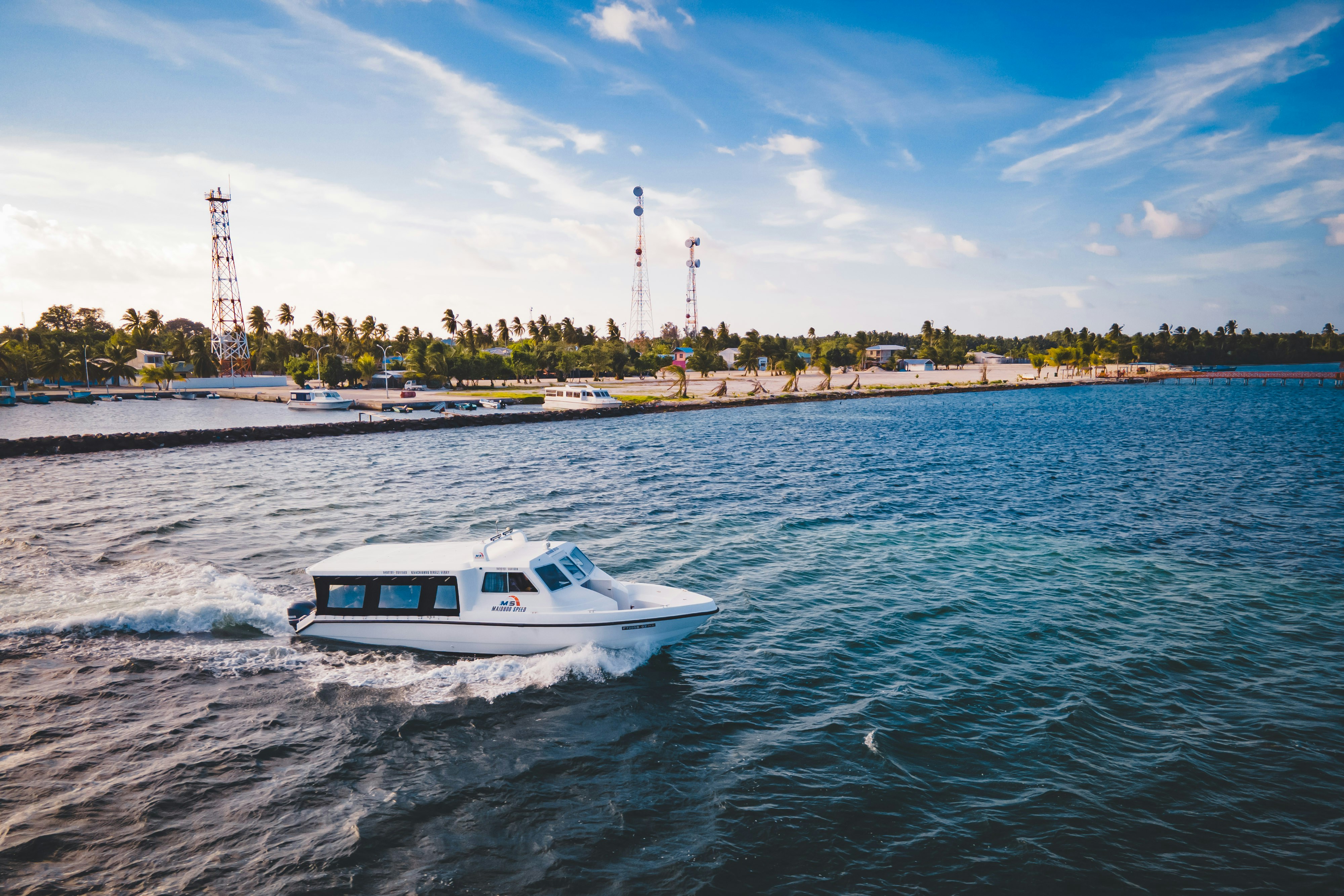 A boat sails across a blue ocean.
